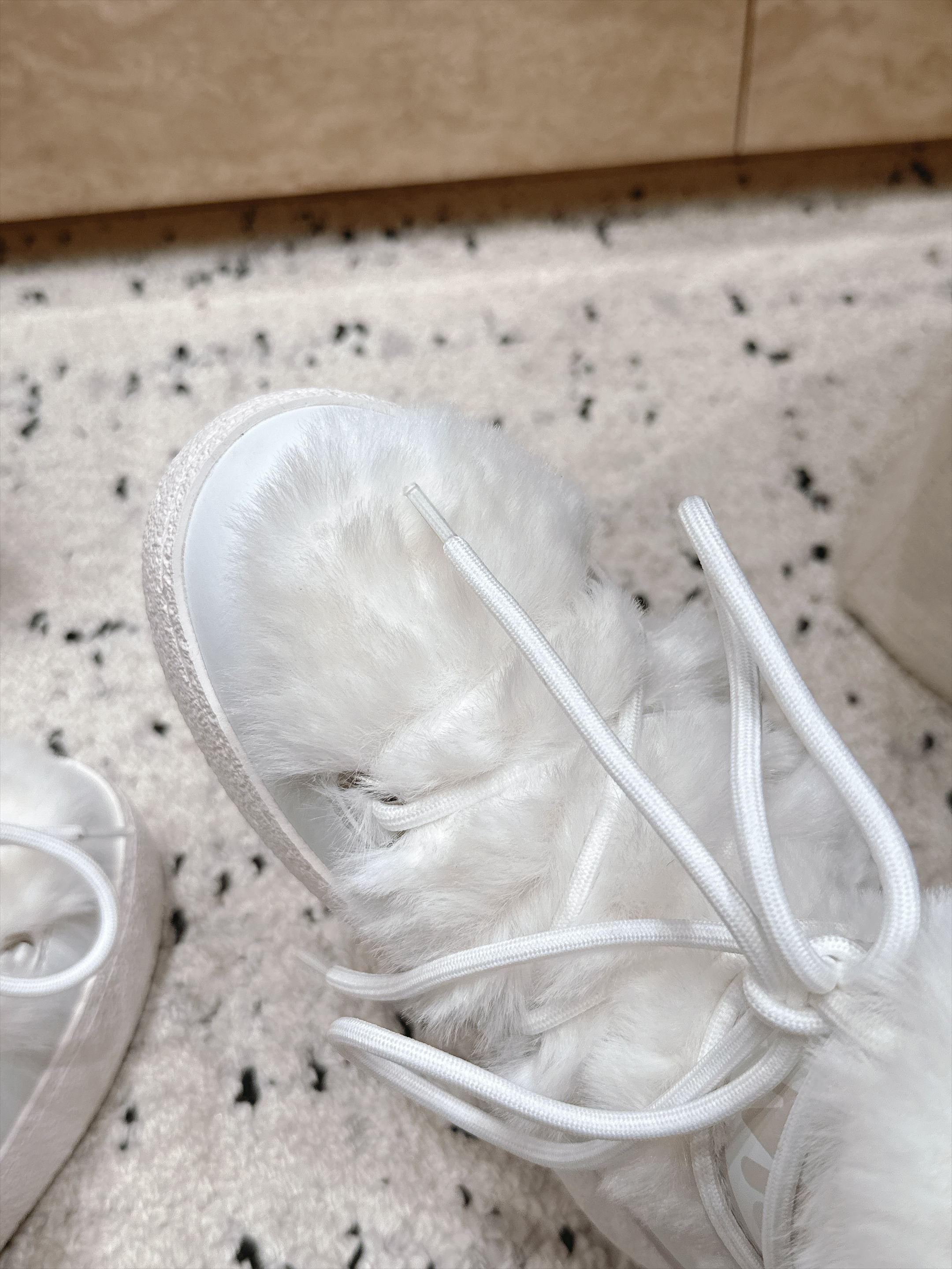 Moon Boot毛绒绑带雪地靴｜冬日甜酷保暖单品 Moon Boot这款毛绒雪地靴，妥妥是冬日氛围感担当，黑色和奶白双