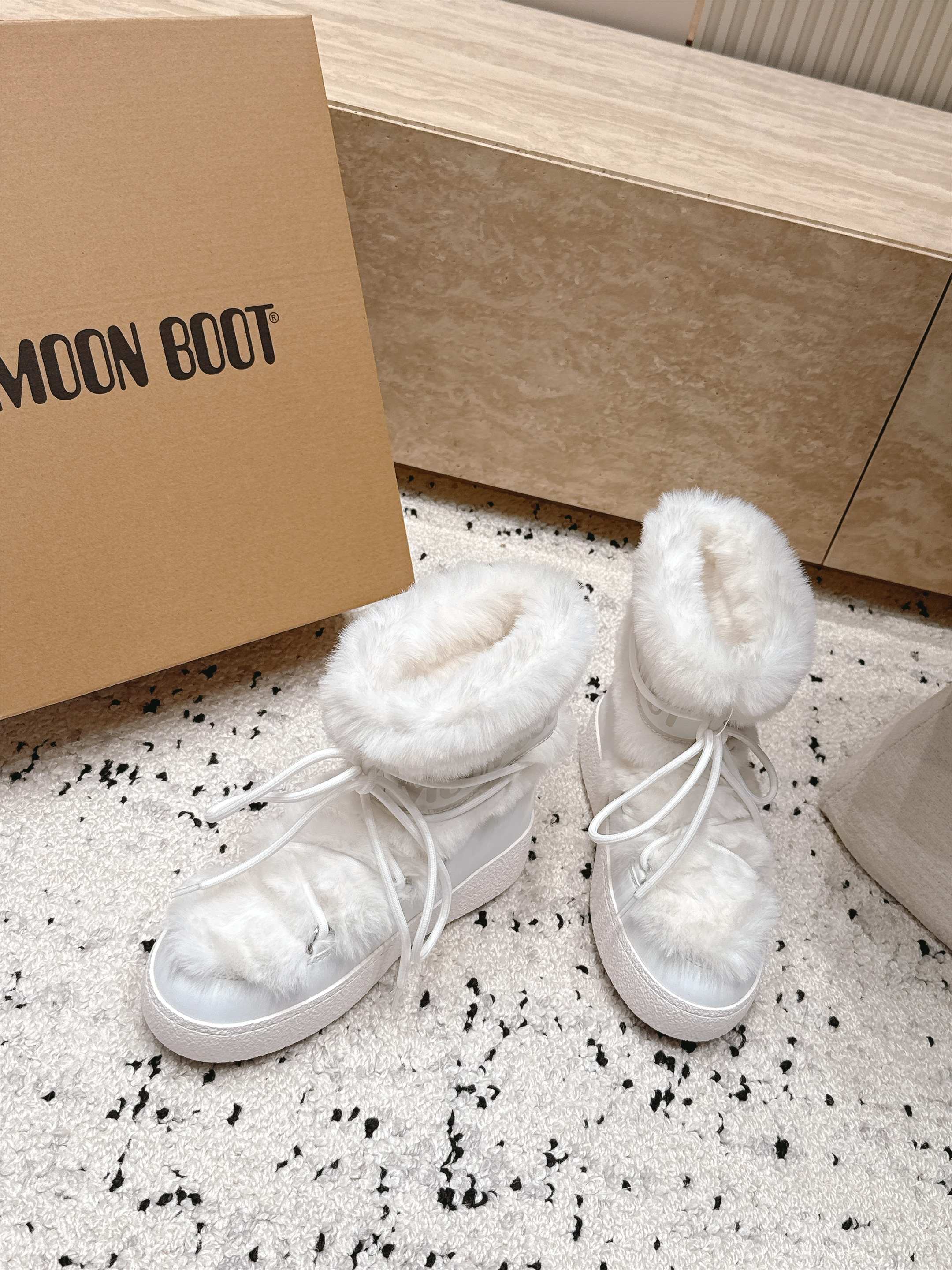 Moon Boot毛绒绑带雪地靴｜冬日甜酷保暖单品 Moon Boot这款毛绒雪地靴，妥妥是冬日氛围感担当，黑色和奶白双