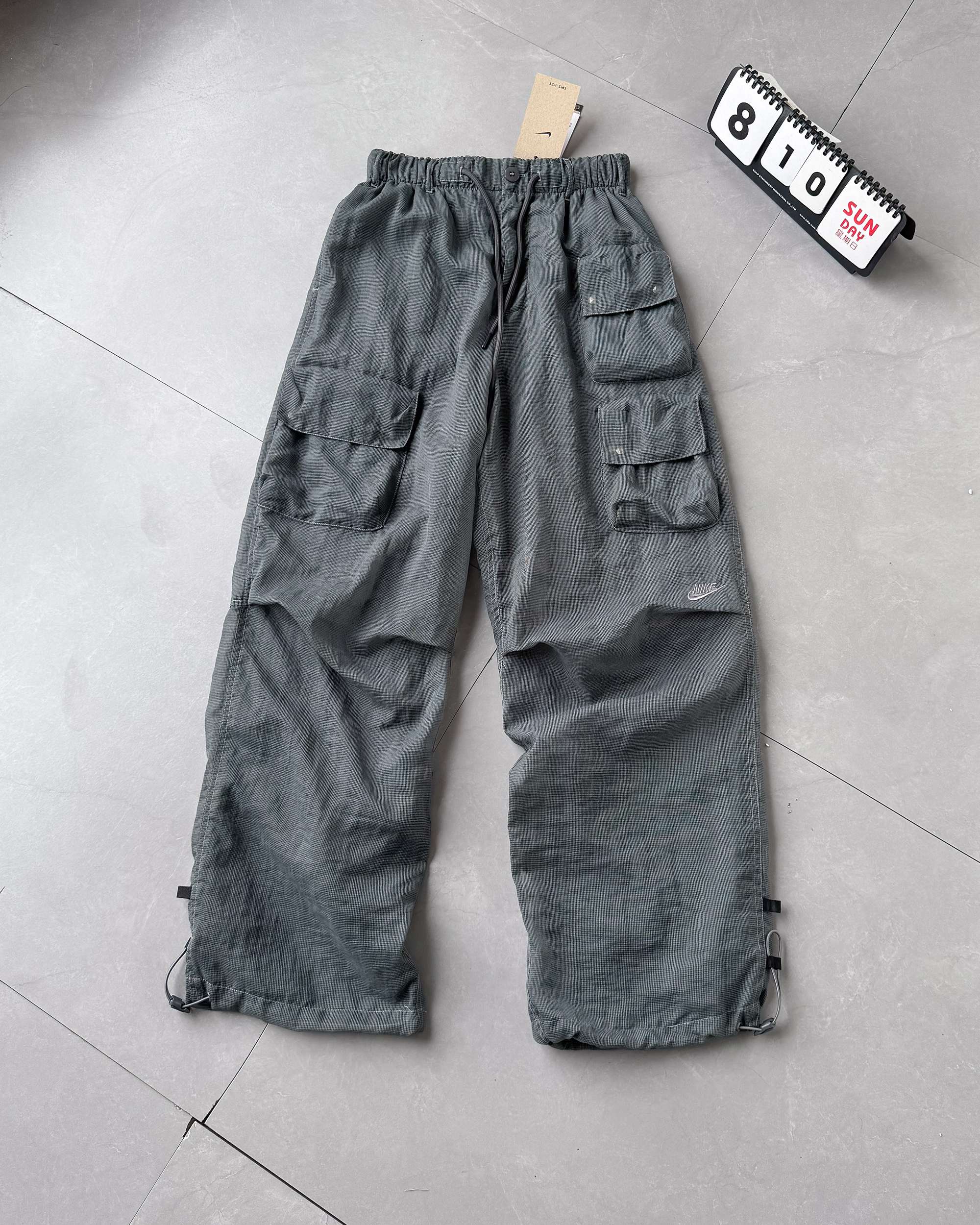 💰145 专为夏天而生双层透气网眼，凉爽的同时还能保护隐私
 耐克 Nike Sportswear Tech Pack 纯色logo刺绣工装梭织衬里多口袋休闲裤 情侣款
夏季透气双层百搭工装裤，专为炎热夏天而生，避免蚊虫叮咬
细节做工辅料1:1 订做， 原版购入，面料定织定染，极为耗时，网面设计透气亲肤，细节请看高清图，多个口袋可以修饰身形又很实用，夏天不喜欢穿短裤得铁子们必入款，虽然是长裤，但是穿起来真的和短裤一样凉爽！！
颜色：铁灰色
货号：FQ3869－068
尺码：S  M  L  XL    松紧腰弹力很大

          裤长     臀围     脚围    腰围     建议
S        96        108       44       64       120斤内
M      98         110       46       67       120-145斤
L       100        112      48       70       145-170斤
XL     102       116      50       73        170-195斤