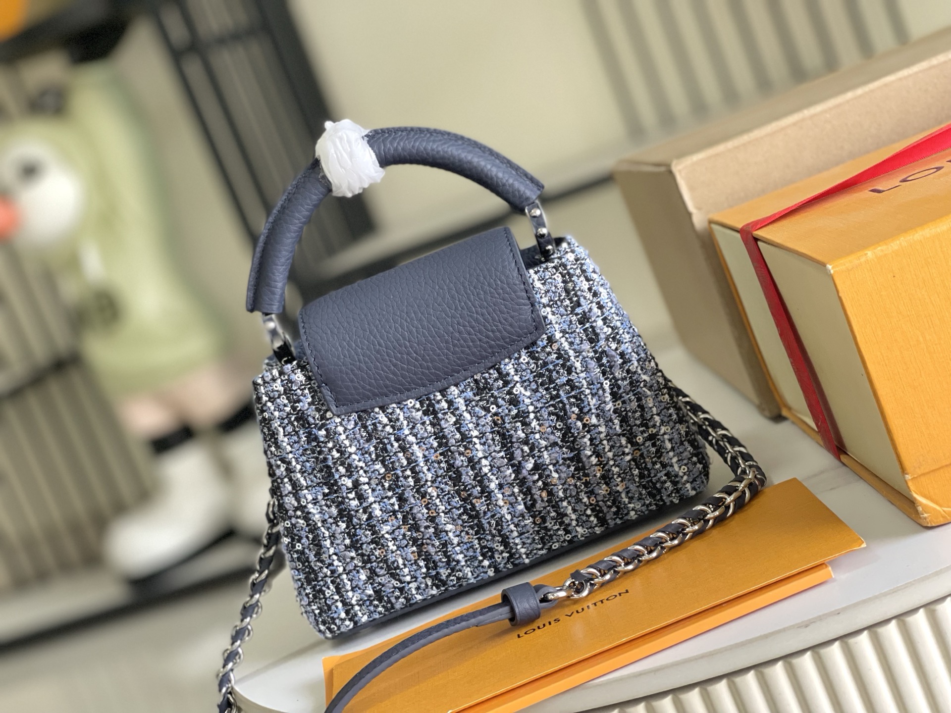 p1200。（163 芯片）特级配全套包装【特级精品原厂皮💋 M12948 迷你 蓝白花呢亮片
CapucinesBB手袋本季讲述全新的Capucines故事。精致的金属色Monogram花卉饰带，使此款经典手袋散发出更加柔美的气质。精致的白色包身搭配金色花冠装饰，优雅而实用。
详细特征21x 13x8cm