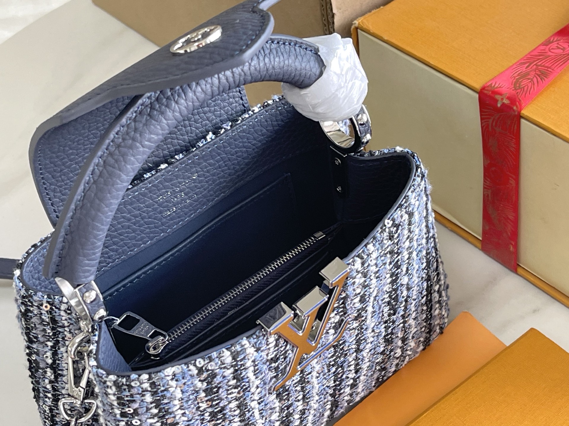 p1200。（163 芯片）特级配全套包装【特级精品原厂皮💋 M12948 迷你 蓝白花呢亮片
CapucinesBB手袋本季讲述全新的Capucines故事。精致的金属色Monogram花卉饰带，使此款经典手袋散发出更加柔美的气质。精致的白色包身搭配金色花冠装饰，优雅而实用。
详细特征21x 13x8cm