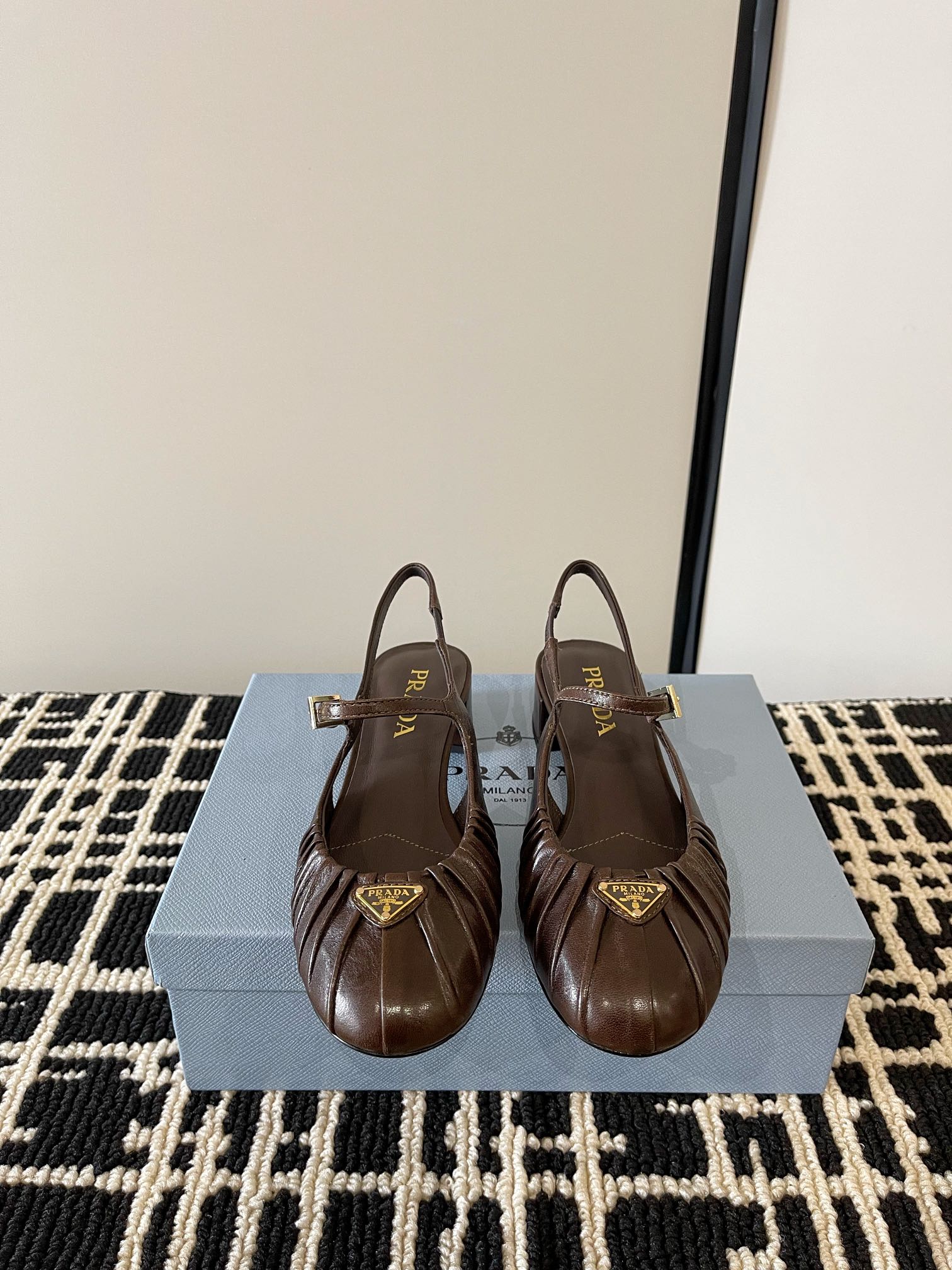 NO:749177,(With high-end airplane case) Prada classic triangle logo back hollow thick-heeled sandals, retro-style pleated leather Mary Jane ballet shoes, thick-heeled single shoes, classic and elegant design, with both retro charm and fashion sense, suitable for various occasions. Made of high-quality leather material, smooth surface, high-quality texture, and has good wear resistance and breathability.  The toe adopts a pleated design, which adds a sense of layering and three-dimensionality to the shoes, while giving it a retro style; there are thin straps at the ankles, which not only serve as a fixation, but also modify the ankle lines, enhancing the overall sense of sophistication. The low-heeled design, with a moderate height, can not only increase the wearer's figure  It has a high temperament and ensures stability and comfort when walking. It is not easy to feel tired after walking for a long time. It is decorated with an enameled triangular metal logo, highlighting classic lines and exquisite and elegant details. The upper is embellished with ribbons and engraved logo metal buckles, and the enameled triangular metal logo!  Customized calfskin upper, sheepskin lining, heel height 4cm, Italian genuine leather outsole, size 35-39 (40.41 custom-made, non-returnable), sandals, prada, prada, sandals, mary jane, cowhide, sheepskin, Leather soles19860909（配高档飞机盒） Prada普拉达 经典三角标后空粗跟凉鞋复古风褶皱皮面玛丽珍芭蕾舞鞋粗跟单鞋 设计经典大方,兼具复古韵味与时尚感,适合多种场合搭配. 采用优质皮革材质,表面光滑,质感上乘,且具备良好的耐磨性和透气性. 鞋头采用了褶皱设计,增添了鞋子的层次感和立体感,同时赋予其复古风情；脚踝处设有细带,不仅起到固定作用,还能修饰脚踝线条,提升整体的精致感.低跟设计,高度适中,既能增加穿着者的身高和气质,又能保证行走时的稳定性和舒适度,长时间行走也不易感到疲劳.饰有涂珐琅三角形金属徽标,彰显经典线条和精致优雅细节.鞋面点缀饰带与雕刻徽标金属搭扣,涂珐琅三角形金属徽标！ 鞋面定制小牛皮 内里垫脚羊皮 跟高4cm 鞋底意大利真皮大底 码数35-39（40.41定做不退换）,凉鞋单鞋,prada,prada,sandals,mary jane,cowhide,sheepskin,Leather soles,Women's Shoes