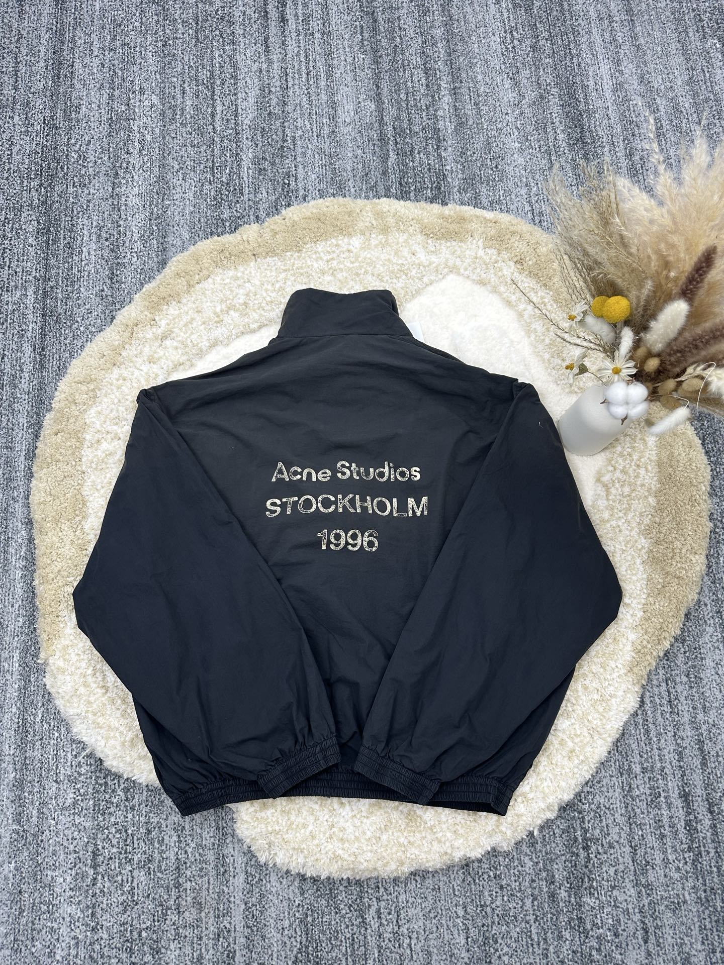 P290,全网顶级版本
Acne Studios 撞色徽标拉链夹克
定制幻光雅棉细织绸 柔软丝滑 舒适贴肤 以做旧黑为色调 那不经意间晕染的做旧效果 邂逅复古情怀载体 幅饰以同质化展示 搭配后幅醒目的 Acne Studios 1996撞色徽标点缀 既有着复古的韵味 又散发着现代的简约时尚感 松紧袖口和下摆设计 巧妙地勾勒出身体线条 在随性中透露出无法忽视的高级感 是街头最具格调的时尚先锋
采用固体印花 胸前印花经过三次菲林网板修改 使用胶浆液体涂料在织物上打印图案 烘烤织物以固定印刷图案
渐变做旧喷马骝工艺 通过在织物表面喷洒不同颜色的染料 实现衣物在不同光线下呈现出丰富的色彩变化 增加视觉层次感
重度孝洗 通过特制溶液 去除污渍且轻微的褪色 再雪花洗 通过强烈的洗涤方式来褪色 使其颜色更为均匀
下摆采用三针像筋拉腰机一次而成 利用机器的特殊针位和送料机构 将松紧带与布料在同一工序中缝合在一起 三针的设计更加牢固 能够均匀地分布压力 确保松紧带与布料紧密贴合
尺码: 42 44 46 48