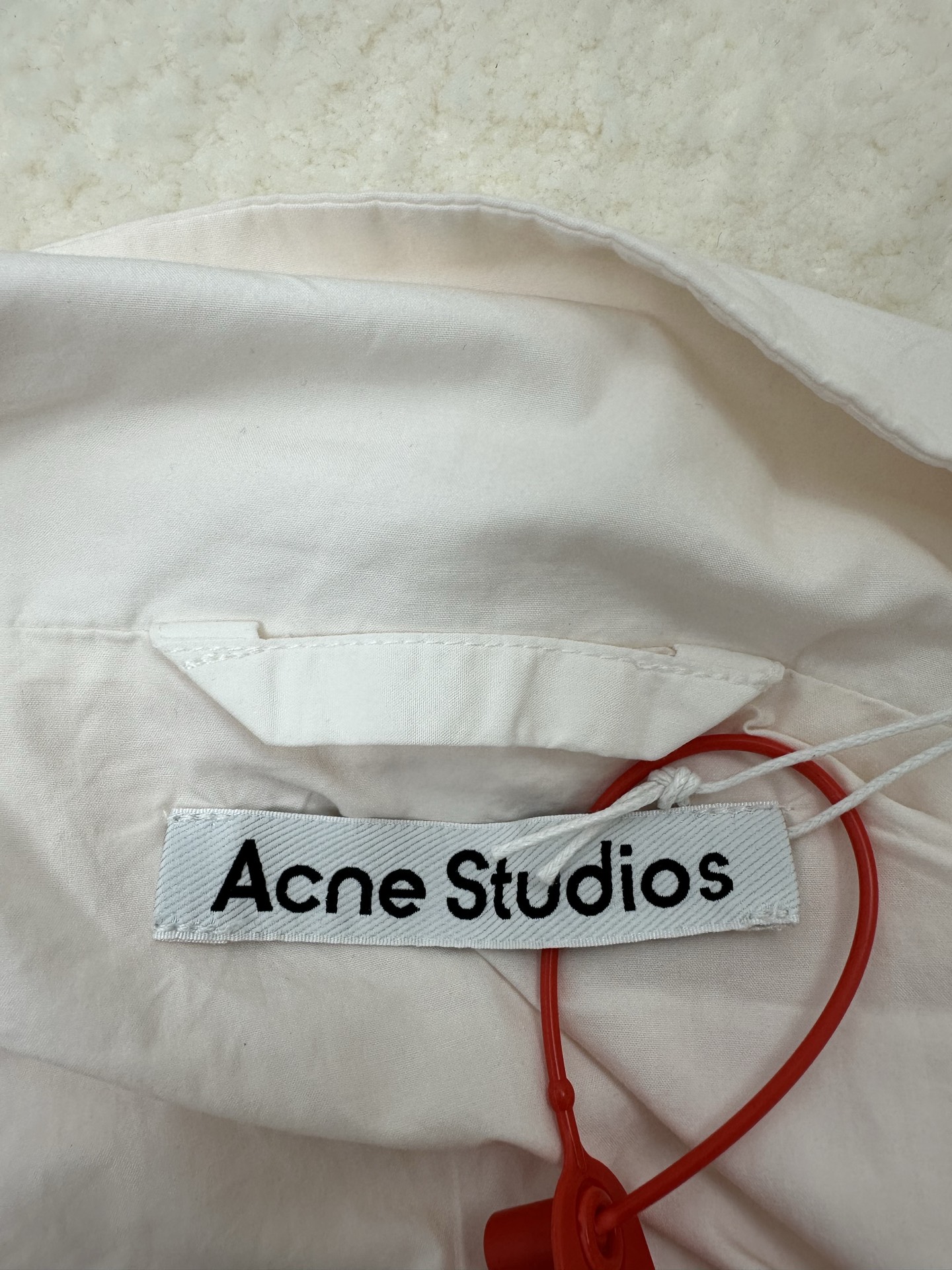 P290,全网顶级版本
Acne Studios 撞色徽标拉链夹克

定制幻光雅棉细织绸 柔软丝滑 舒适贴肤 以泛黄的米白为色调 那不经意间晕染的做旧效果 邂逅复古情怀载体 幅饰以同质化展示 搭配后幅醒目的 Acne Studios 1996撞色徽标点缀 既有着复古的韵味 又散发着现代的简约时尚感 松紧袖口和下摆设计 巧妙地勾勒出身体线条 在随性中透露出无法忽视的高级感 是街头最具格调的时尚先锋

采用固体印花 胸前印花经过三次菲林网板修改 使用胶浆液体涂料在织物上打印图案 烘烤织物以固定印刷图案

渐变做旧喷马骝工艺 通过在织物表面喷洒不同颜色的染料 实现衣物在不同光线下呈现出丰富的色彩变化 增加视觉层次感

重度孝洗 通过特制溶液 去除污渍且轻微的褪色 再雪花洗 通过强烈的洗涤方式来褪色 使其颜色更为均匀

下摆采用三针像筋拉腰机一次而成 利用机器的特殊针位和送料机构 将松紧带与布料在同一工序中缝合在一起 三针的设计更加牢固 能够均匀地分布压力 确保松紧带与布料紧密贴合
尺码： 42 44 46 48