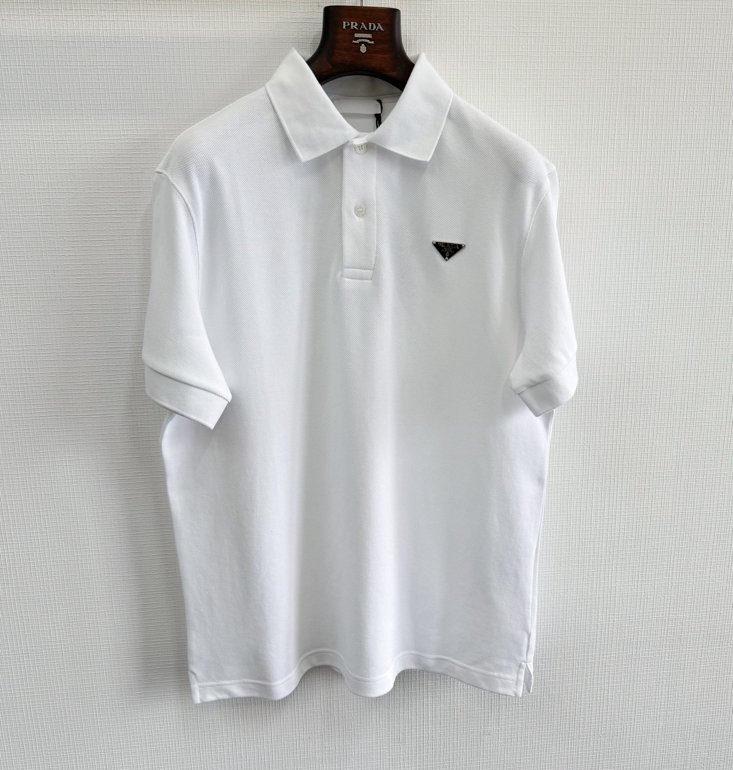 NO:823530,Prad 25ss triangle label cotton pique polo shirt 195g 40ss combed cotton compact siro spun yarn large eyeball plain weave. The finished fabric is shaped according to the fabric width, retaining the same honeycomb mesh large eyeball ground pattern as the Y version. Customized triangle hardware accessories, matching color matching horizontal machine woven flat collar ribbed cuff strips, natural shell tarot shell round edge hand-stitched buttons in the front and center size:  s/m/l/xl,Prada-clothing,prada,prada,19860909Prad 25ss三角标棉质珠地布Polo衫 195g 40ss精梳棉紧密赛络纺纱线大眼珠地平纹布 成品布顺布门幅定型,保留了跟Y版一样的蜂窝网状大眼珠地纹,定制三角五金配件,配套对色横版机织造扁机领罗纹袖口条,前中采用天然贝壳塔罗贝圆边手缝扣size: s/m/l/xl,普拉达-服装,prada,prada,,Women's clothing