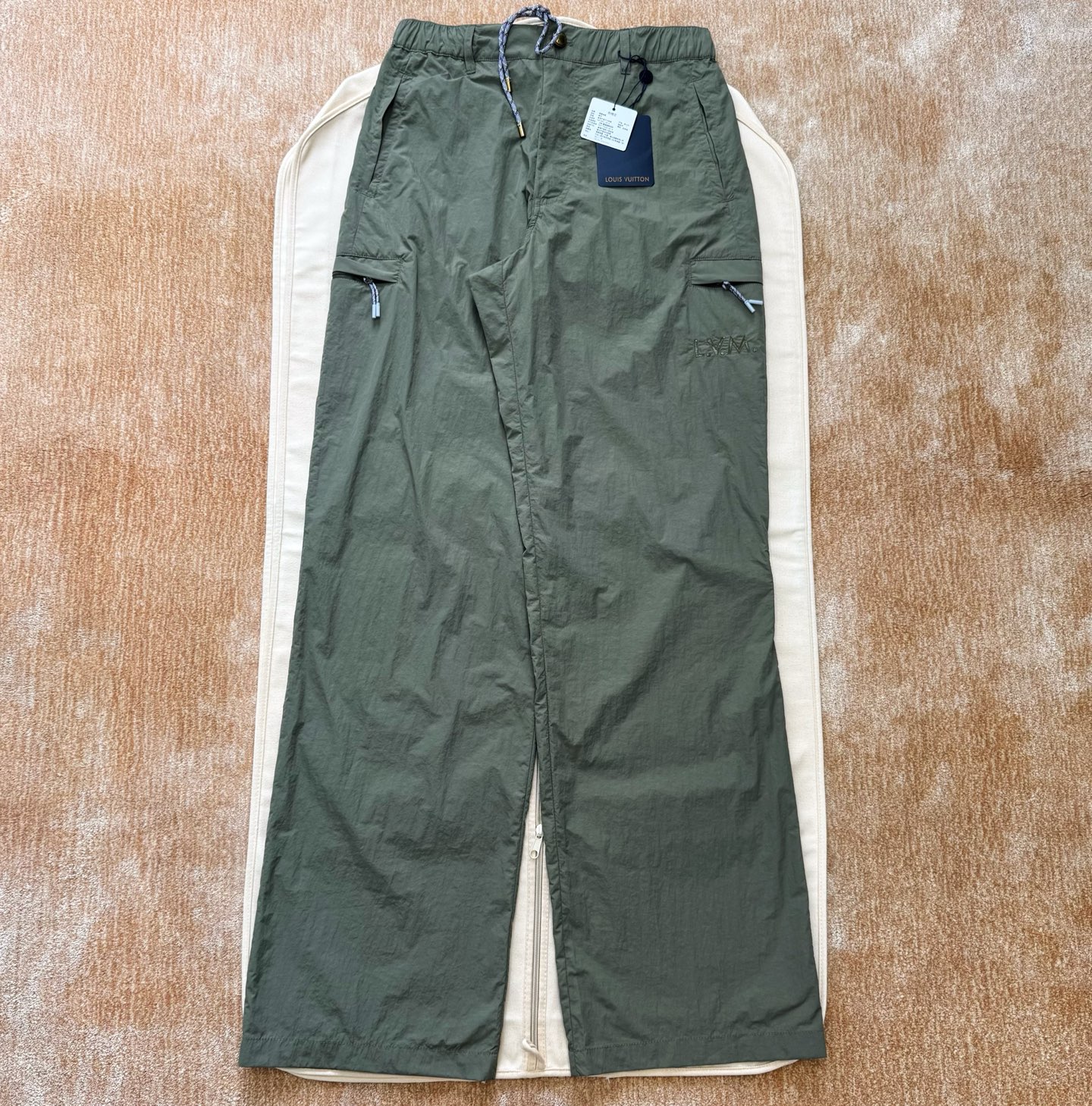 NO:775857,1v 26ss technical fabric mountaineering trousers. Technical nylon woven fabric. After special coating or finishing, it can also be water-repellent and windproof. The left side of the pocket is decorated with logo embroidery.  Three-needle rice grain embroidery is a high-density embroidery process that uses extremely fine stitches to simulate the texture of rice grains. A special stitch method is used to simulate the hand-painted texture. Irregular stitches with varying thicknesses are used to imitate the randomness and whitening effect of hand-painted strokes. The classic and simple side pockets on the edged side pockets are convenient for quick access. The flap pockets are located on both sides of the thighs and are closed with flaps and buttons to improve the performance.  Provides safe storage space, prevents items from slipping out, and enhances workwear style. The rear welt pocket is a back pocket with more refined craftsmanship and neater lines. The pocket is edged with welt and is usually used to store small items. The standard straight-leg hiking pants version, and the distressed metal button placket are the finishing touches. Size: 44/46/48/50, Louis Vuitton - clothing, louis  vuitton,198609091v 26ss 科技面料登山长裤 科技锦纶梭织面料,特殊涂层或后整理后,还可具备防泼水、防风等功能性,口袋左侧饰有标识刺绣 三针米粒绣是一种以极细线迹模拟米粒状颗粒质感的高密度刺绣工艺,模拟手绘质感采用特殊针法,通过不规则、有粗细变化的线迹来模仿手绘笔触的随意感和飞白效果,镶边侧袋经典简洁的侧插袋,便于快速取物,翻盖口袋位于大腿两侧,通过翻盖与纽扣闭合,提供安全储物空间,防止物品滑出,并强化工装风格,后部嵌线口袋一种工艺更精致、线条更利落的后袋,袋口用嵌线包边,通常用于收纳小件物品,标准直筒登山裤版型,做旧金属纽扣门襟是点睛细节size:44/46/48/50,路易威登-服装,louis vuitton,,Women's clothing