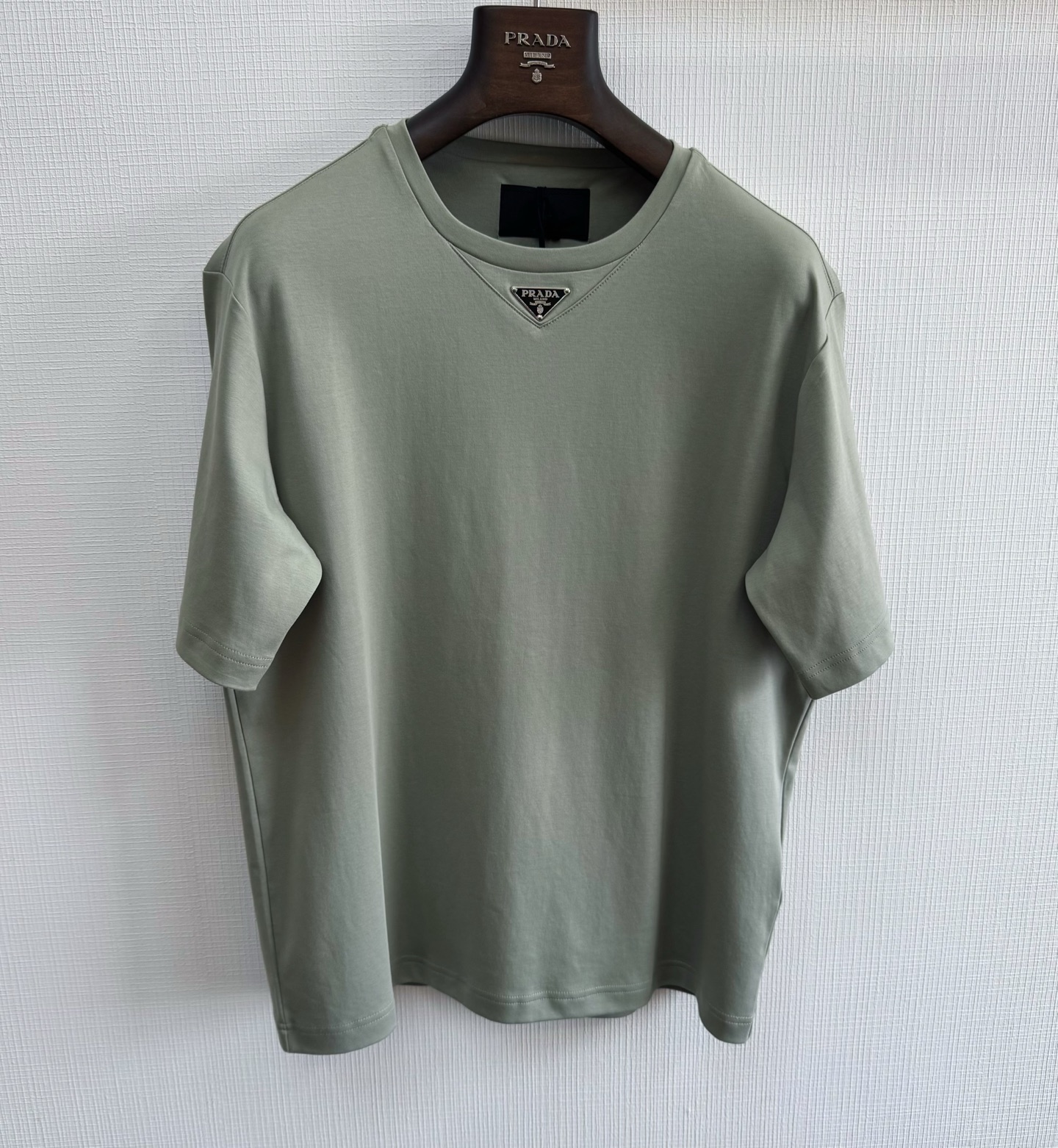 NO:823455,Prad 26ss triangle steel logo T-shirt with chip 195g 60 count liquid nitrogen double-sided cotton, liquid nitrogen black technology. The cotton fiber has been tempered by -196°C liquid nitrogen, forming billions of breathable micropores on the surface, which is 3 times more breathable than ordinary cotton.  The double-sided craftsmanship upgrades the touch, and the fabric is more silky and wrinkle-resistant, soft and sweat-absorbent, as if you are wearing clouds on your body. The version design adopts a triangular fork in the front, a sweat-folding back collar pocket on the back panel, and powder-swept positioning on the back collar pocket. Flat machine hidden stitching, the finished product has a smooth routing, and a triangular front panel  The label is made of pure steel, an integrated mold is opened, the film is injected once and the embryo is produced, and the finished product is produced by the paint-smoothing and baking process later. Size: s/m/l/xl, Prada-clothing, prada, prada, tees, t-shirt,19860909Prad 26ss三角钢标T恤 带芯片 195g 60支液氮双面棉,液氮黑科技 经过-196°C液氮淬炼的棉纤维,表面形成亿万级透气微孔,比普通棉布透气性提升3倍 双面工艺让触感升级,面料更加丝滑抗皱,软糯吸汗,仿佛把云朵穿在身上版型设计采用前中开三角叉,后幅带折汗后领兜,后领兜扫粉定位,平车暗线车缝,成品走线圆顺,前幅三角标采用纯钢材质,开一体化模具,一次注膜出胚,后期点漆抹平烤漆工艺出成品size:s/m/l/xl,普拉达-服装,prada,prada,tees，t-shirt,,Women's clothing