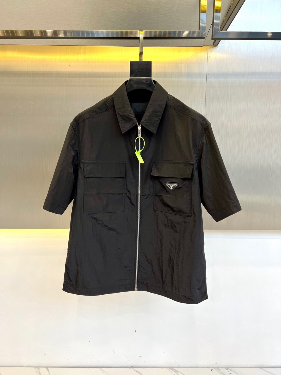 NO:161293,Prada/Prada men's short-sleeved lightweight Re-Nylon shirt. This short-sleeved shirt combines practical details with sports elements to present a minimalist design in a contemporary style. It is made of light Re-Nylon material, which presents a square silhouette, with a pocket that is full of capacity on the front, while the zippered lace adds a simple and practical fashion touch. The enamel triangle metal logo highlights the unique classic features. Classic collar, flip patch pocket, straight bottom edge, zipper closure · Enamel triangle metal logo on the front · 48-56 (model 173, 143 catties upper body 50 yards),,prada,prada,shirts,T-shirt,alexander wang19860909Prada/普拉达男士短袖轻盈Re-Nylon衬衫. 这款短袖衬衫将实用细节与运动元素相结合,呈现出当代风格的极简设计.选用轻盈的Re-Nylon材质打造,呈现方正廓形,正面点缀容量充裕的口袋,而拉链衣襟则增添了一抹简洁而实用的时尚触感.涂珐琅三角形金属徽标彰显别具一格的经典特色. ·经典衣领·翻盖贴袋·平直底边·拉链开合 ·正面涂珐琅三角形金属徽标· 48-56（模特173,143斤上身50码）,,prada,prada,shirts,T-shirt,alexander wang,Men's clothing