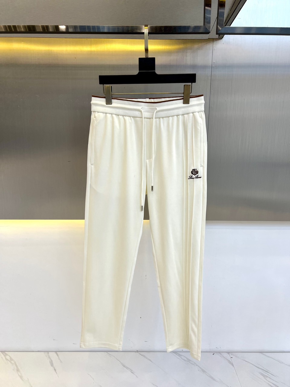 NO:153923,Loro Piana, Italian LP spring and summer new fashionable letter embroidered casual pants for men. Inspired by the dawn of the Amalfi coast in southern Italy, the function of jogging pants and the elegance of high-end garments is reconstructed. The waist adopts the integrated molding process of the original cloth and is matched with 4cm invisible elastic bands. While retaining the freedom of movement, it reshapes the aesthetics of the waistline with traceless design. The front slant insert bag innovatively uses natural dyed and woven contrasting piping, and achieves the matte gradient effect through 5 wash and fading tests, paying tribute to the glaze color philosophy of Sicily ceramic craftsmen.  80-day silk and 20 linen blend fabrics were selected. After double-sided wooling process, each square meter of fabric forms   micron-level pores. Combined with the natural antibacterial properties of flax fiber, the somatosensory temperature is automatically adjusted. 5. The pearl-colored matte hardware OGO inlaid in the back bag is hand-polished using the engraving skills of the Renaissance goldsmith. The 0.05mm error control makes the metal surface look like a silk matte texture, forming a low-key glow with a 15° refractive angle with sunlight 3.  From the 16-stitched edge locking craftsmanship inherited by Milan's haute couture workshop to the high-density buried car thread of 22 needles per inch, this jogging pants uses a precision that exceeds the standards of sportswear to build a seamless switching between urban elites in business and casual scenes. 2. When the shadow of the olive tree in Tuscany passes through the trouser face, the Italian craftsmanship is writing a new dressing poem in fabric language. 48-56 (please report height and weight if you place an order), loro piana, loro piana, alexander wang19860909Loro Piana诺悠翩雅、意大利LP春夏新款时尚字母刺绣休闲裤男士抽绳长裤.以意大利南部阿玛尔菲海岸的晨曦为灵感,将慢跑裤的机能性与高级成衣的优雅感重新解构.腰部采用原身布一体成型工艺,搭配4cm隐形松紧带,在保留运动自由度的同时,以无痕设计重塑腰线美学.前幅斜插袋创新运用自然染织的撞色滚边,通过5次水洗褪色测试实现雾面渐变效果,致敬西西里岛陶艺匠人的釉色哲学. 甄选80天丝与20亚麻混纺面料,经双面烧毛工艺处理后,每平方米织物形成 微米级气孔,配合亚麻纤维的天然抑菌特性,实现体感温度自动调节5.后幅一字袋镶嵌的珍珠色亚光五金OGO,采用文艺复兴时期金匠的錾刻技艺手工打磨,0.05mm误差控制使金属表面呈现丝绸般哑光质感,与日光形成15°折射角的低调辉光3. 从米兰高定工坊传承的16道锁边工艺,到每英寸22针的高密度埋夹车线,这条慢跑裤以超越运动服饰标准的精工,构筑都市精英在商务与休闲场景中的无缝切换2.当托斯卡纳的橄榄树影掠过裤面经纬,意大利匠造精神正以织物语言书写新的穿着诗篇.48-56（下单请报身高体重）,,loro piana,loro piana,alexander wang,Men's clothing