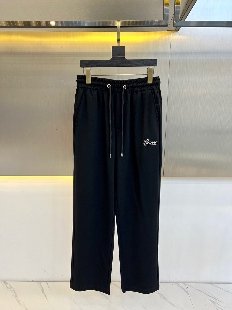 NO:160109,Gucci, 2025 spring and summer new fashion letter embroidered casual pants for men, wide drawstring trousers. The cotton fiber blended fabric is light and luxurious, with a delicate touch and excellent breathability, as if it is covered with a layer of soft clouds on the skin. This high-end blended fabric not only shows an extraordinary texture, but also gives the wearer a unique elegant temperament. The classic badge embroidery design on the front shows the unique charm of the brand, and the retro and trendy atmosphere intertwines it, showing a unique fashion taste. The high-elastic drawstring elastic waist design is not only easy to put on and take off, but also freely adjusts according to the personal waist circumference. Whether it is tight matching or loose style, it can be easily controlled!  M-3XL (please report height and weight by placing an order), gucci, alexander wang19860909Gucci、2025春夏新款时尚字母刺绣休闲裤男士宽筒抽绳长裤.甄选客供棉质纤维混纺面料,质地轻盈而奢华,触感细腻如丝,透气性极佳,仿佛为肌肤披上了一层轻柔的云朵.这种高级混纺面料不仅展现出非凡的质感,更赋予了穿着者一种独特的优雅气质.前幅的经典徽章刺绣设计,细节之处彰显品牌的独特魅力,复古与潮流的气息交织其中,展现出与众不同的时尚品味.高弹力的抽绳松紧裤腰设计,不仅方便穿脱,更可根据个人腰围自由调节,无论是紧身搭配还是宽松风格,都能轻松驾驭！M-3XL（下单请报身高体重）,,gucci,alexander wang,Men's clothing