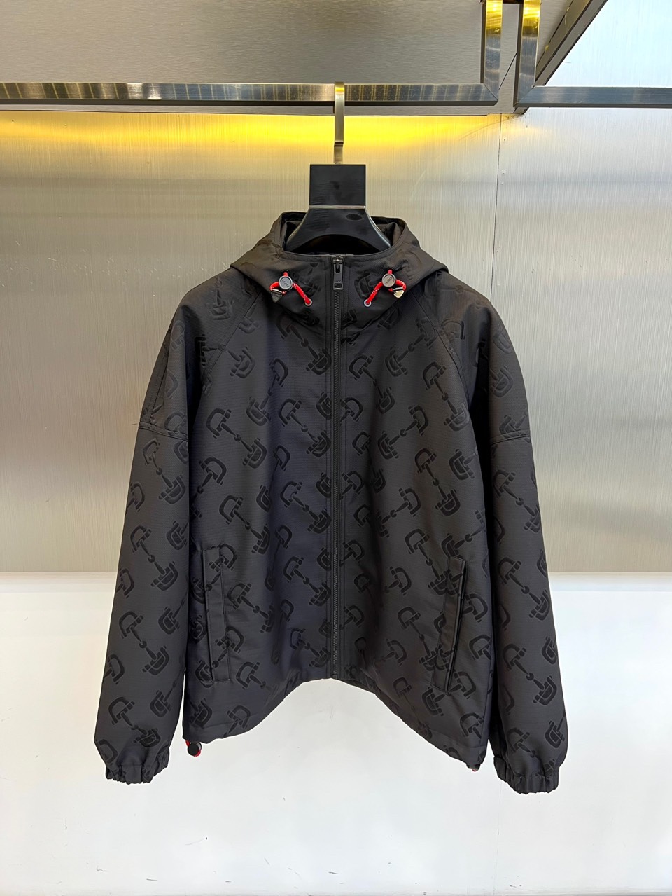 NO:514420,Gucc, Gucc, functional hooded jacket with matte black fabric covered with three-dimensional totem, and high-end polyester fiber creates waterproof functional properties. The full zipper design is matched with a striking red drawstring, and contrasting color adjustment buckles illuminate the overall shape. The elastic cuffs form a contrasting tailoring with the loose hem, and the back hides the details of the reflective strips. The suspension system uses a professional display hanger, champagne gold metal wall and warm light belt to highlight the high-end texture. 48-56 (model 173, 143 catties upper body 50 yards), gucci,gucci, jackets & coats,hats,alexander wang19860909Gucc古驰、 暗纹机能连帽夹克 哑光黑面料铺满立体暗纹图腾,高级聚酯纤维打造防水机能属性.全拉链设计搭配醒目红色抽绳,撞色调节扣点亮整体造型.弹性袖口与宽松下摆形成对比剪裁,后背暗藏反光条细节.悬挂系统采用专业展示衣架,香槟金金属墙面与暖光灯带烘托高端质感.48-56（模特173,143斤上身50码）,,gucci,gucci,jackets & coats,hats,alexander wang,Men's clothing