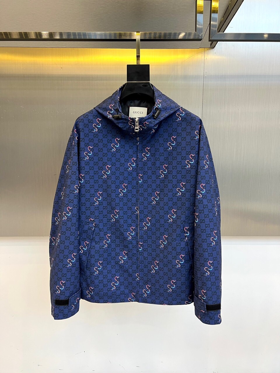 NO:513598,Gucc, 25FW neon snake pattern hooded jacket jacket, double G dark pattern × neon snake attack, classic dark blue base material is densely covered with GUCCI's iconic dark pattern, pink and blue two-color spiritual snake winds around, injecting Renaissance fantasy into the street genes. The white collar on the neckline is like a secret signature, declaring pure bloodline. Functional and luxurious chemical reaction The whole piece uses high-density windproof fabric, with silver-tooth zippers scratching the night. The slightly oversize silhouette takes into account comfort and styling. Whether it is layered or worn alone, it is the trendy coordinate of walking. 48-56 (model 173, 143 catties upper body 50 yards),,gucci,gucci,versace,hoodie,sweatshirts,jackets & coats,jackets & coats,hats,alexander wang19860909Gucc古驰、25FW霓虹蛇纹连帽夹克外套  双G暗纹 × 霓虹蛇袭 经典深蓝底料密布GUCCI标志性暗纹,粉蓝双色灵蛇蜿蜒游走,将文艺复兴的狂想注入街头基因.领口白标如隐秘签名,宣告纯正血统. 机能与奢华的化学反应 全件采用高密度防风面料,银齿拉链划破夜色.略微oversize的廓形兼顾舒适与造型感,无论叠穿卫衣或单穿都是行走的潮流坐标. 48-56（模特173,143斤上身50码）,,gucci,gucci,versace,hoodie,sweatshirts,jackets & coats,jackets & coats,hats,alexander wang,Men's clothing