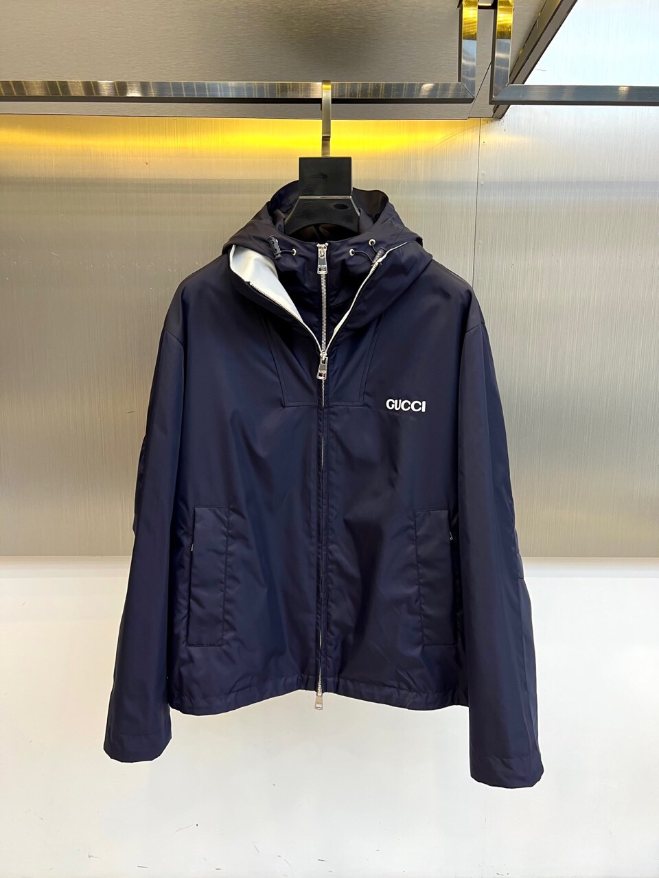 NO:513607,Gucc, 25s autumn and winter new hooded jacket, fake two-piece design. Classic design, details wins. Deep midnight blue fabric with silver grey lining, collides to create a cool and high-end feeling. The white 'GUCCI' logo on the left chest is simple and eye-catching, with metal zippers and three-dimensional tailoring outlines, and the hooded design takes into account both practicality and street style. Texture game between light and shadow The cool metal frame and warm yellow light strips intertwined to set off the low-key luster of the jacket. Whether it is business and leisure or urban exploration, a piece of light and night scenes can be easily controlled and become a style symbol in the wardrobe that never fades. Each stitch inherits the century-old ingenuity of GUCCI. The label and lining hide the brand genes, suitable for a modern gentleman who pursues 'no noise, self-sound'.  48-56 (model 173, 143 catties upper body 50 sizes), gucci, gucci, jackets & coats, hats, alexander wang19860909Gucc古驰、25s秋冬新品连帽夹克,假两件设计. 经典设计,细节制胜 深邃午夜蓝面料搭配银灰内衬,碰撞出冷冽高级感.左胸白色“GUCCI”徽标简约醒目,金属拉链与立体剪裁勾勒利落轮廓,连帽设计兼顾实用与街头格调. 光影间的质感游戏 冷调金属边框与暖黄灯带交织,衬托夹克的低调光泽.无论是商务休闲还是城市探索,一件轻松驾驭昼夜场景,成为衣橱中永不褪色的风格符号. 每一针脚皆承袭GUCCI百年匠心,标签与内衬暗藏品牌基因,适合追求“不喧哗,自有声”的现代绅士. 48-56（模特173,143斤上身50码）,,gucci,gucci,jackets & coats,hats,alexander wang,Men's clothing