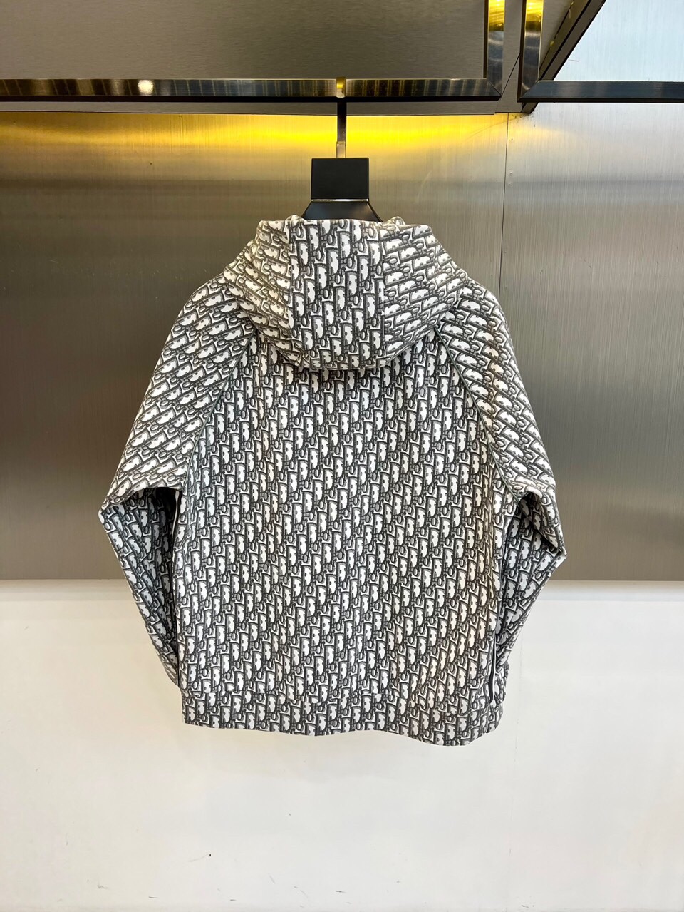 
Dior

纯白底色铺满经典灰色字母印花，100%精梳棉打造亲肤质感。全拉链设计搭配可调节抽绳连帽，5