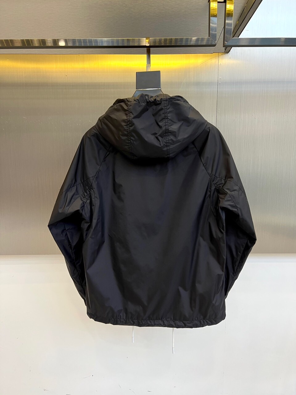 
Prad普拉、25FW黑色机能风连帽夹克外套

哑光尼龙面料打造轻盈防水性能，标志性蓝色拉链与白色抽绳