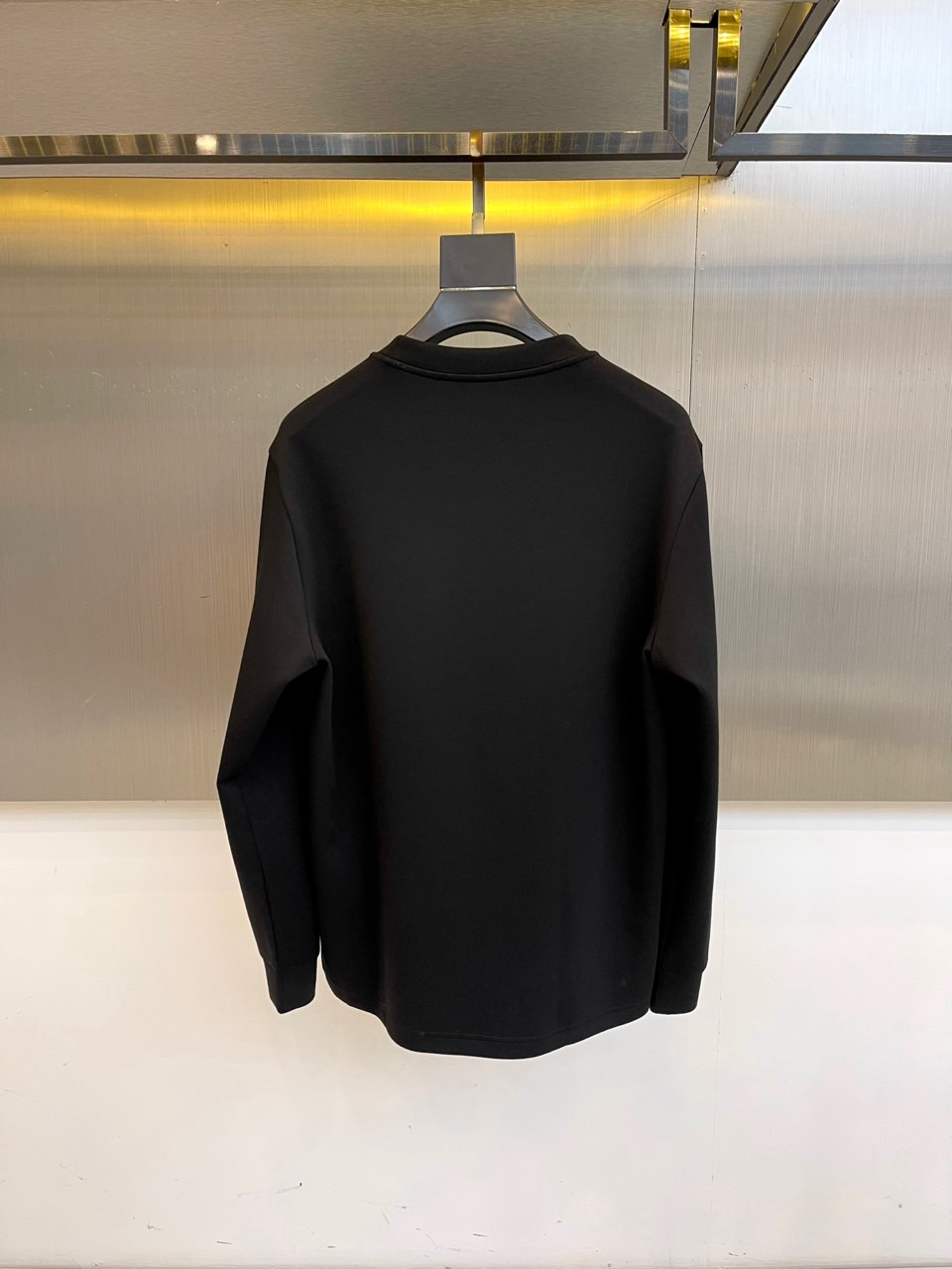 DIO迪奥、2025秋冬长袖T恤卫衣。胸前左侧装饰性口袋与领口内侧的经典老花图案相呼应，正中央