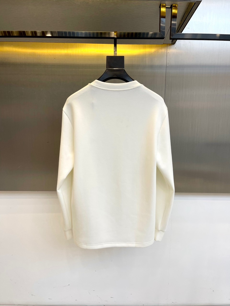 DIO迪奥、2025秋冬长袖T恤卫衣。胸前左侧装饰性口袋与领口内侧的经典老花图案相呼应，正中央