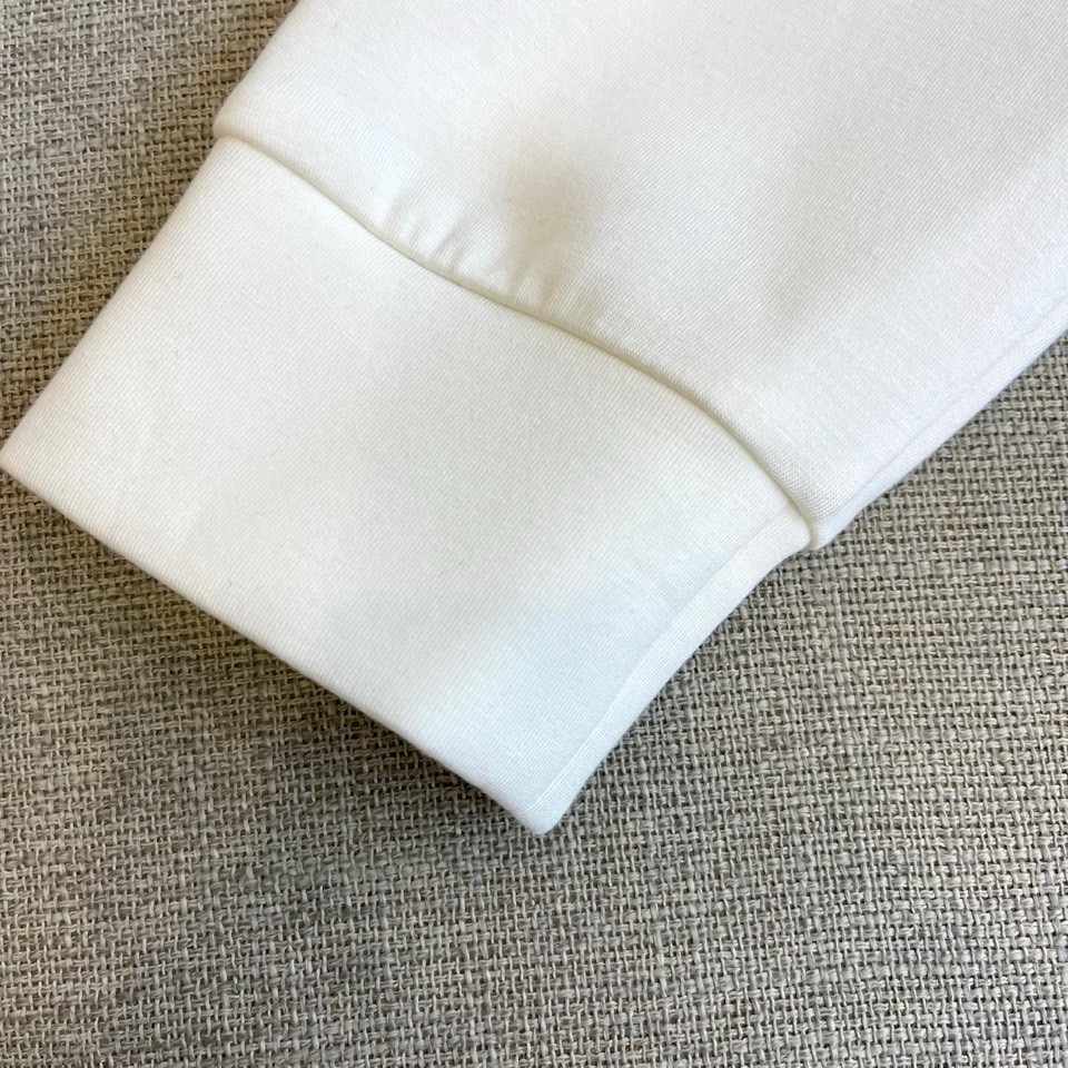 DIO迪奥、2025秋冬长袖T恤卫衣。胸前左侧装饰性口袋与领口内侧的经典老花图案相呼应，正中央