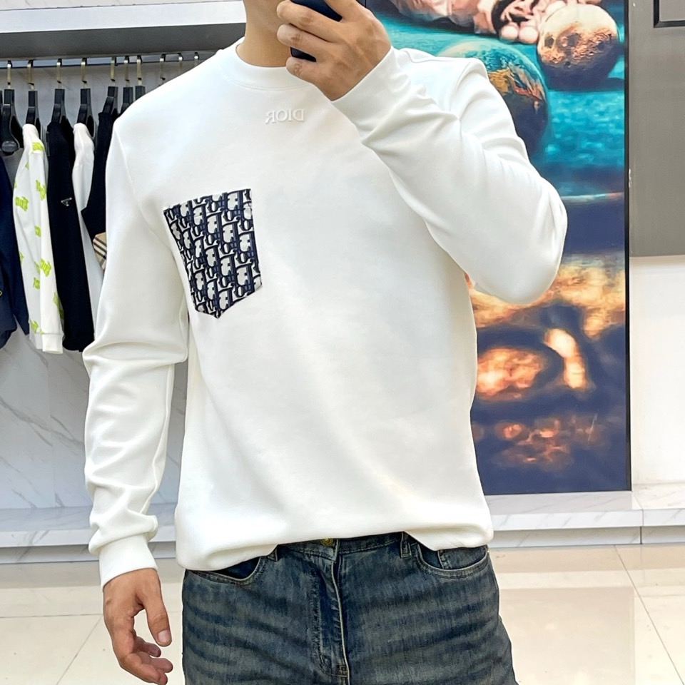 DIO迪奥、2025秋冬长袖T恤卫衣。胸前左侧装饰性口袋与领口内侧的经典老花图案相呼应，正中央