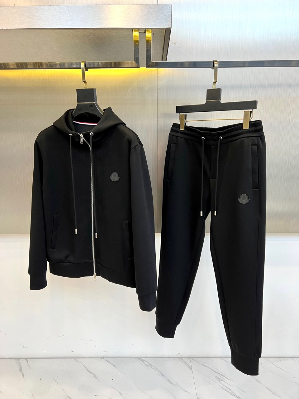 MON蒙口、2025秋冬全新运动套装，以纯粹哑光黑重塑运动美学。航天级弹力面料如第二层肌肤般贴合，在暗色