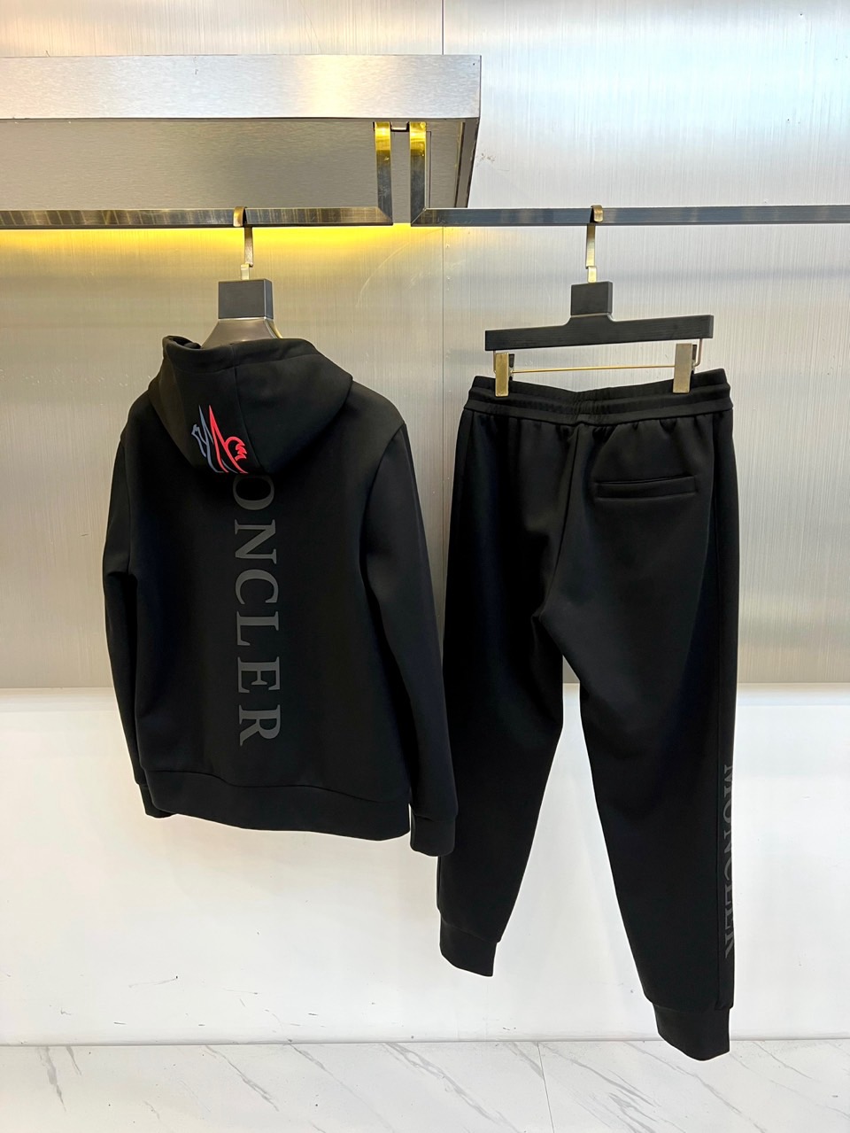 MON蒙口、2025秋冬全新运动套装，以纯粹哑光黑重塑运动美学。航天级弹力面料如第二层肌肤般贴合，在暗色