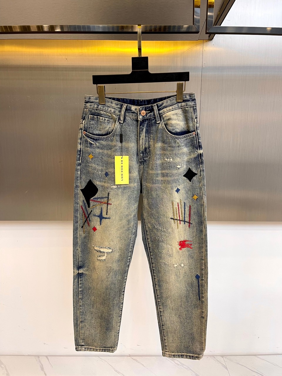 BUR巴宝莉、2025秋冬艺术丹宁牛仔裤，将Burberry标志性格纹解构为黑色菱形矩阵，搭配彩色几何刺