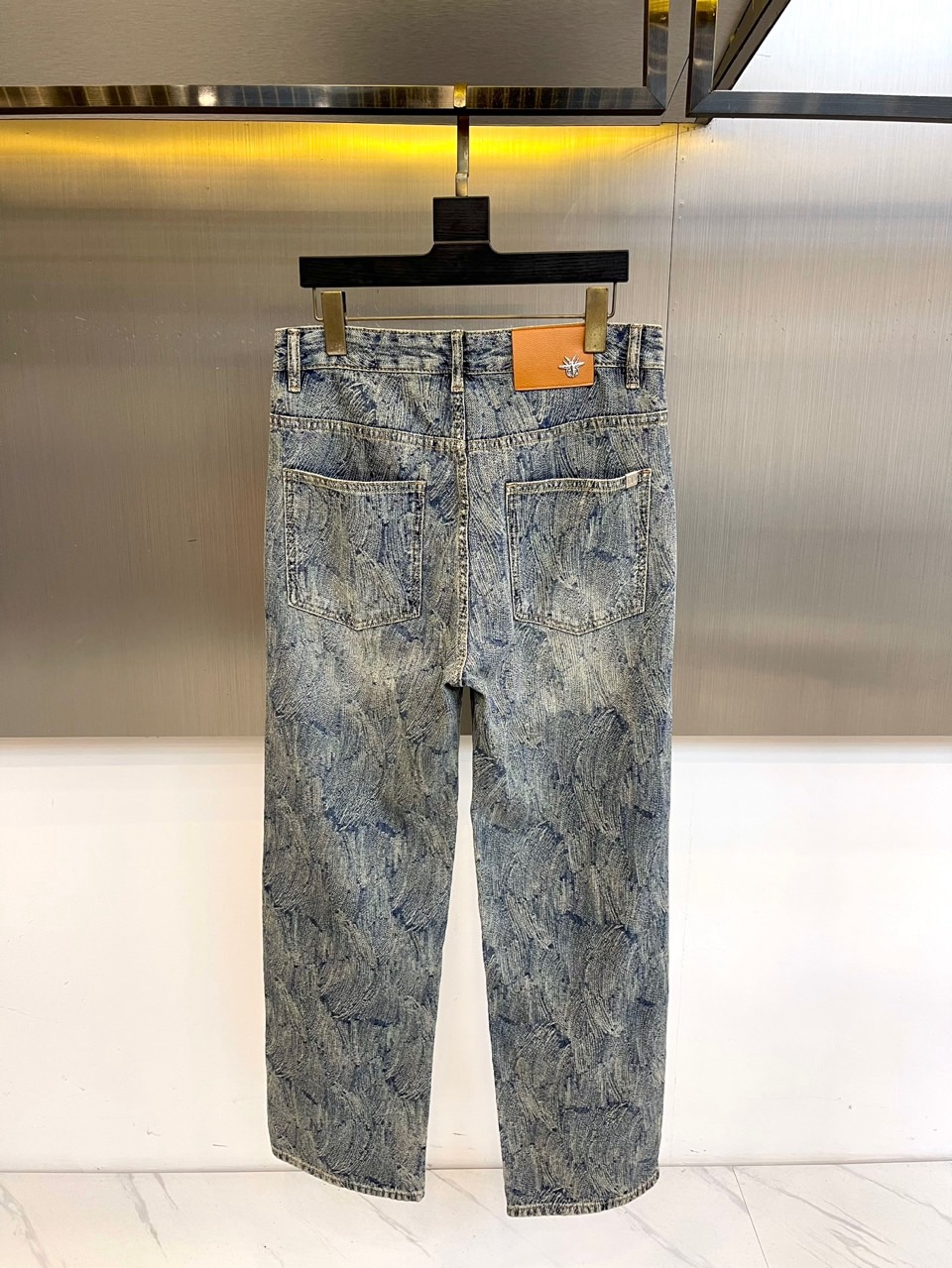 Dio迪奥、2025秋冬新款男士牛仔裤，采用意大利顶级丹宁面料，浅蓝水洗基底晕染出羽毛状暗纹。右后袋白色