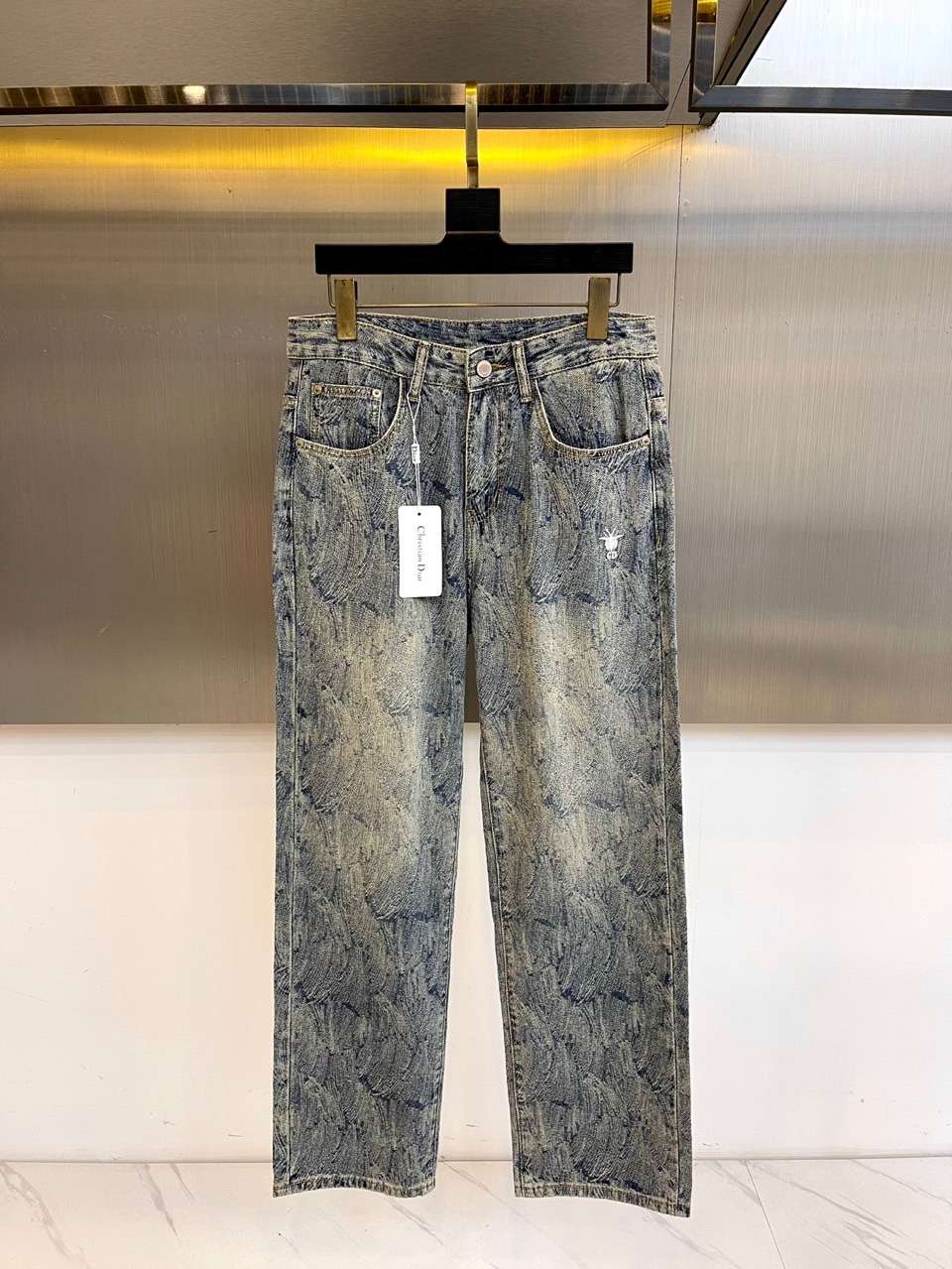 Dio迪奥、2025秋冬新款男士牛仔裤，采用意大利顶级丹宁面料，浅蓝水洗基底晕染出羽毛状暗纹。右后袋白色