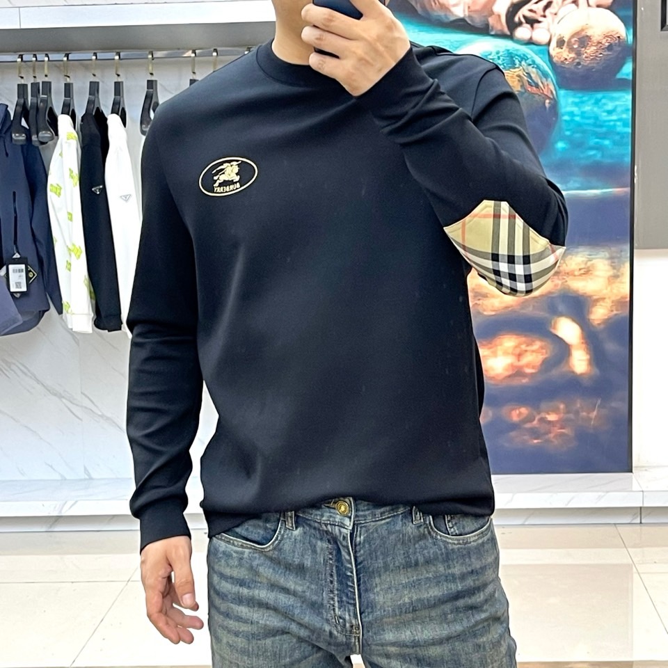 巴宝莉、2025秋冬长袖打底衫。左胸椭圆形金色徽标镌刻品牌基因，领口内侧格纹暗藏经典传承——这是PRAD