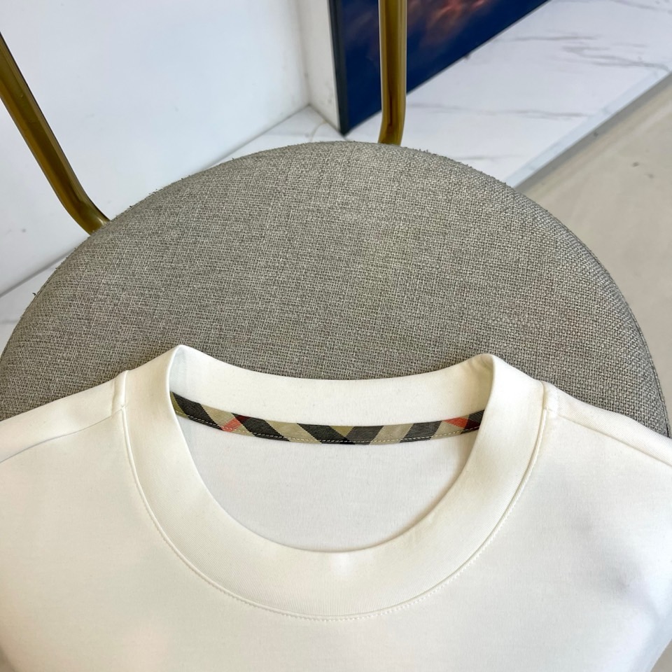 巴宝莉、2025秋冬长袖打底衫。左胸椭圆形金色徽标镌刻品牌基因，领口内侧格纹暗藏经典传承——这是PRAD