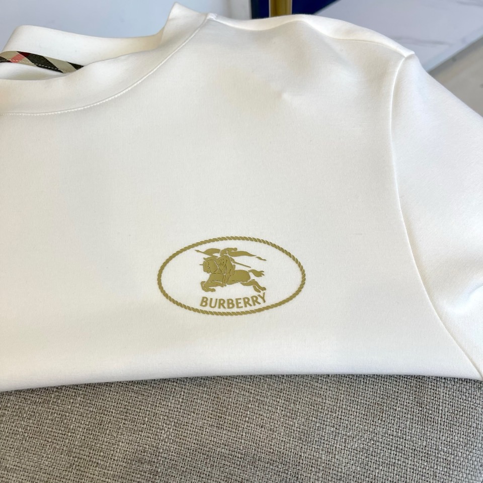 巴宝莉、2025秋冬长袖打底衫。左胸椭圆形金色徽标镌刻品牌基因，领口内侧格纹暗藏经典传承——这是PRAD