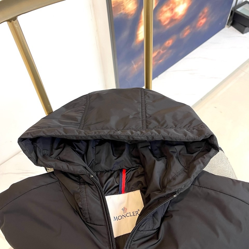 Mon蒙口、2025秋冬连帽棉服夹克外套。MONCLER黑色连帽羽绒服,以立体绗缝工艺勾勒雪域轮廓。肩带