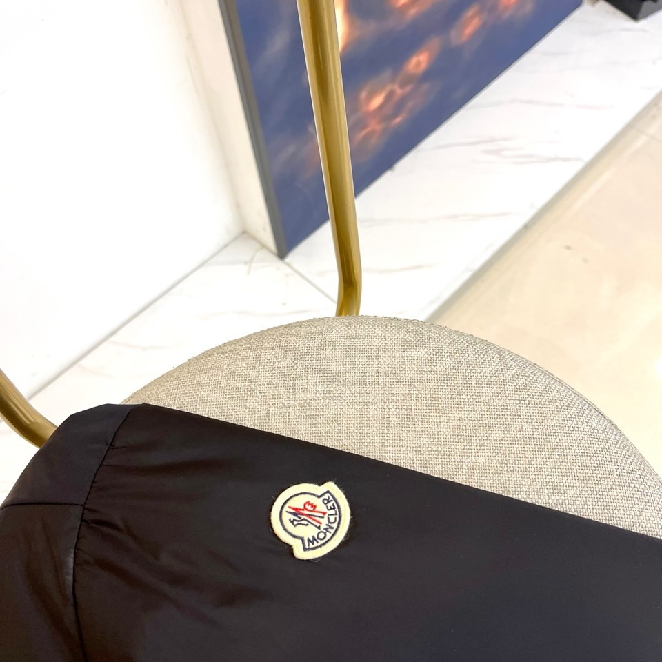 Mon蒙口、2025秋冬连帽棉服夹克外套。MONCLER黑色连帽羽绒服,以立体绗缝工艺勾勒雪域轮廓。肩带