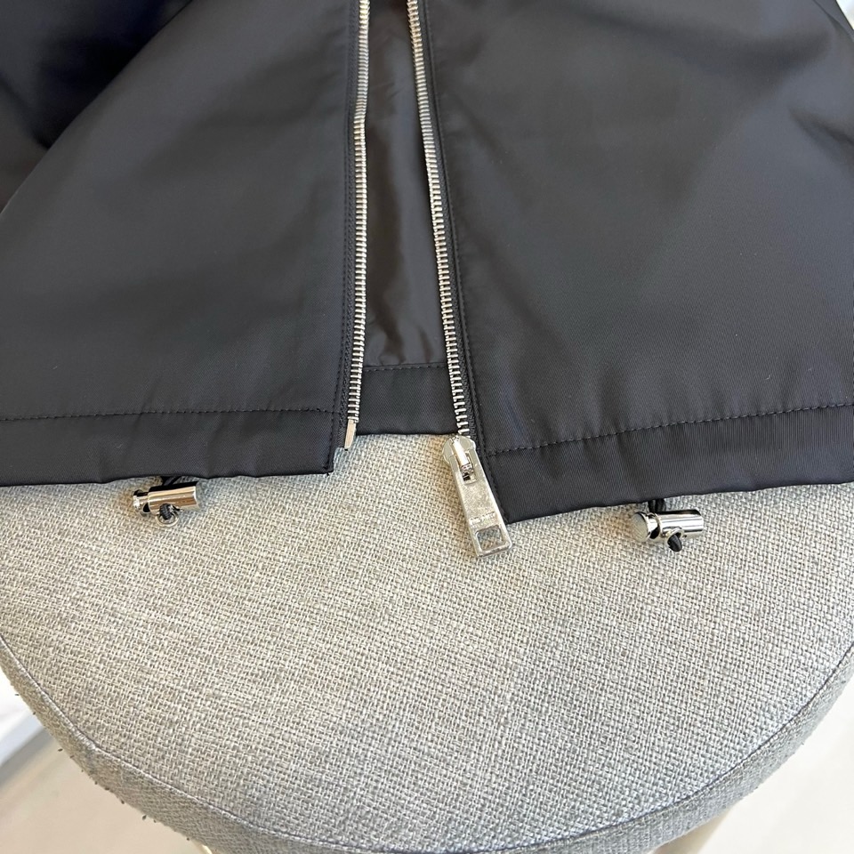 Prada 2025秋冬夹克。【高品质】这款Re-Nylon衬衫廓形简约流畅，融入运动细节，饰以涂珐琅三