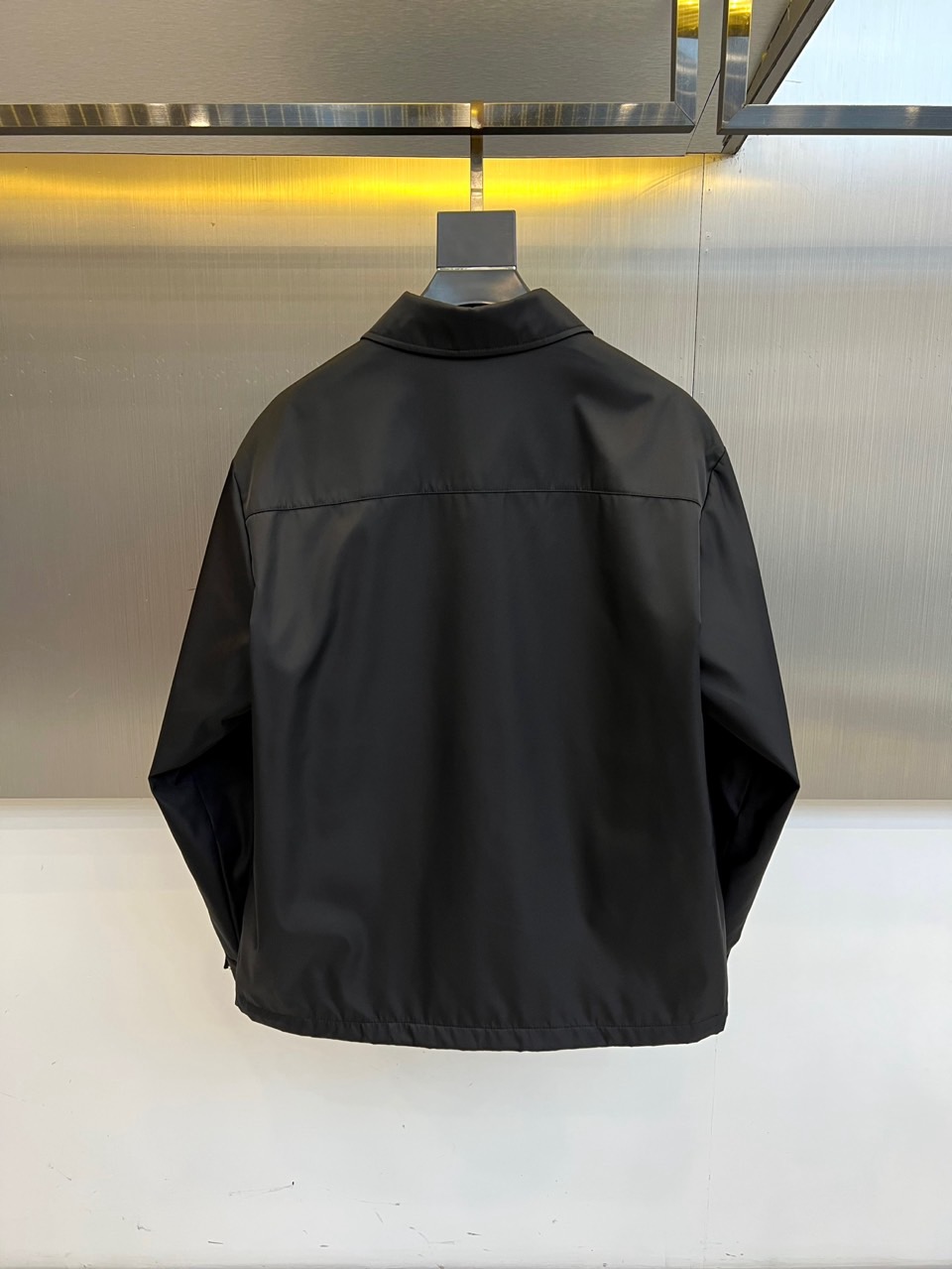 Prada 2025秋冬夹克。【高品质】这款Re-Nylon衬衫廓形简约流畅，融入运动细节，饰以涂珐琅三