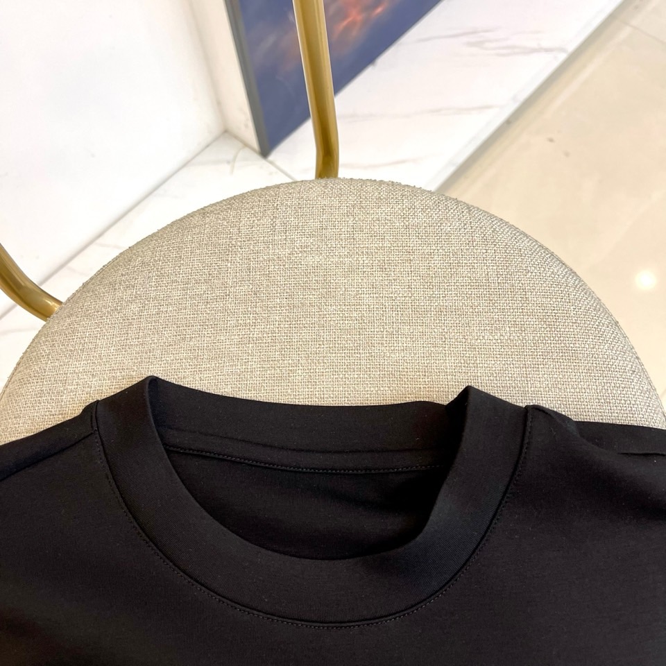 Prad普拉、2025秋冬长袖T恤卫衣。左胸椭圆形金色徽标镌刻品牌基因，领口内侧格纹暗藏经典传承——这是