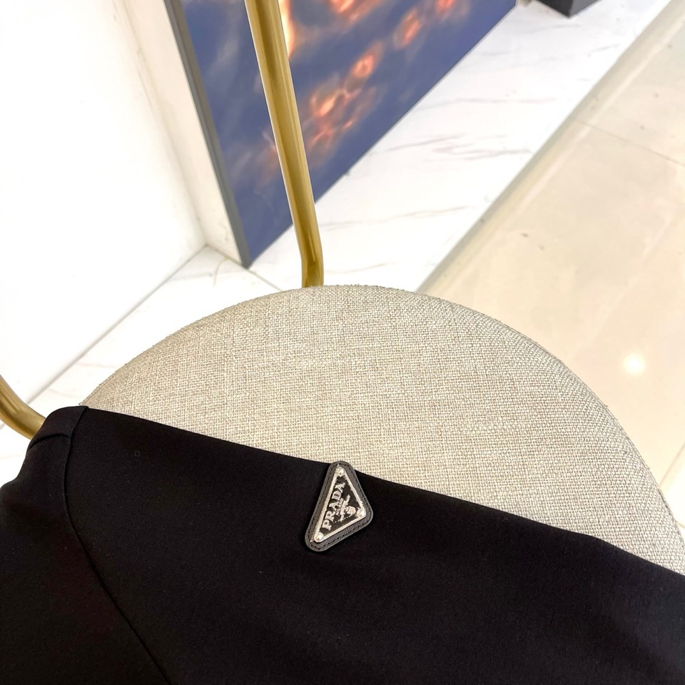 Prad普拉、2025秋冬长袖T恤卫衣。左胸椭圆形金色徽标镌刻品牌基因，领口内侧格纹暗藏经典传承——这是