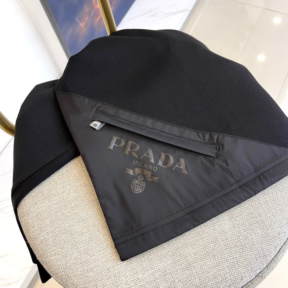 Prad普拉、2025秋冬长袖T恤卫衣。左胸椭圆形金色徽标镌刻品牌基因，领口内侧格纹暗藏经典传承——这是