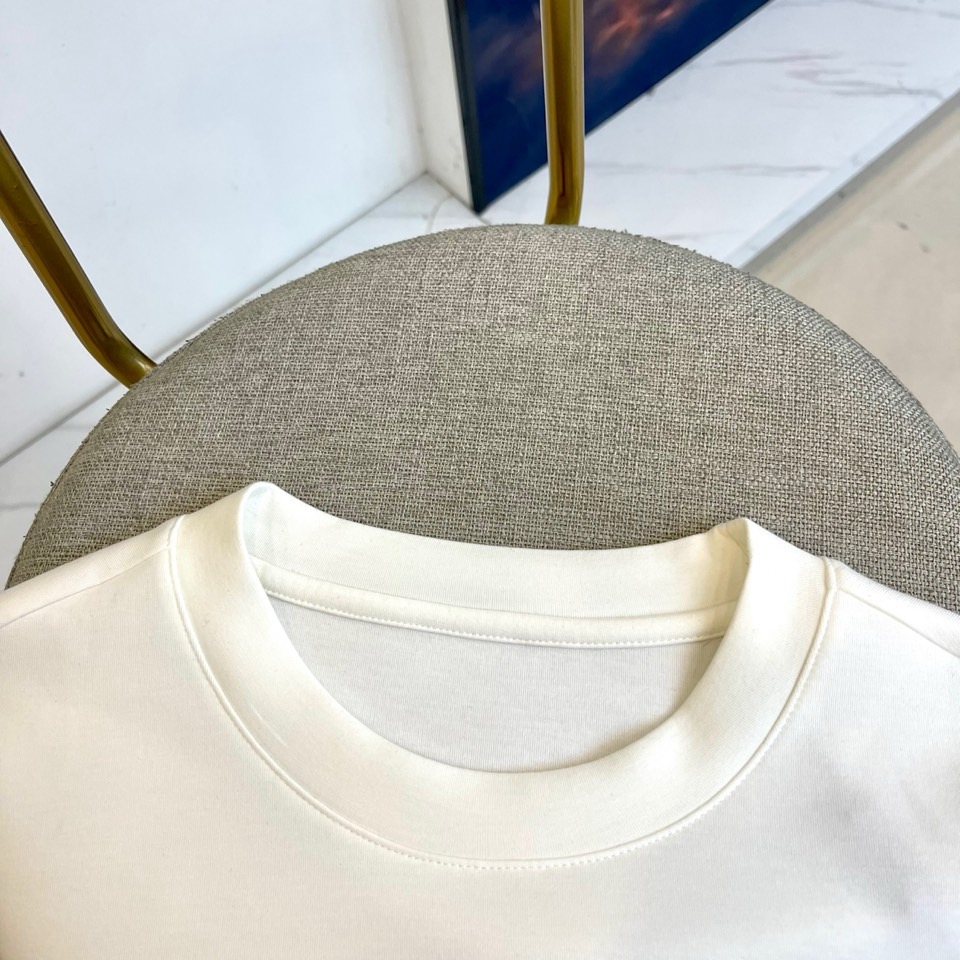 Prad普拉、2025秋冬长袖T恤卫衣。左胸椭圆形金色徽标镌刻品牌基因，领口内侧格纹暗藏经典传承——这是