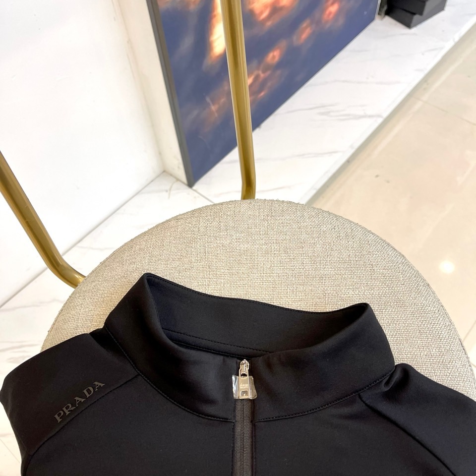 Prad普拉、2025秋冬长袖卫衣T恤。PRADA白色长袖打底衫，以半拉链立领设计诠释现代主义精髓。左胸