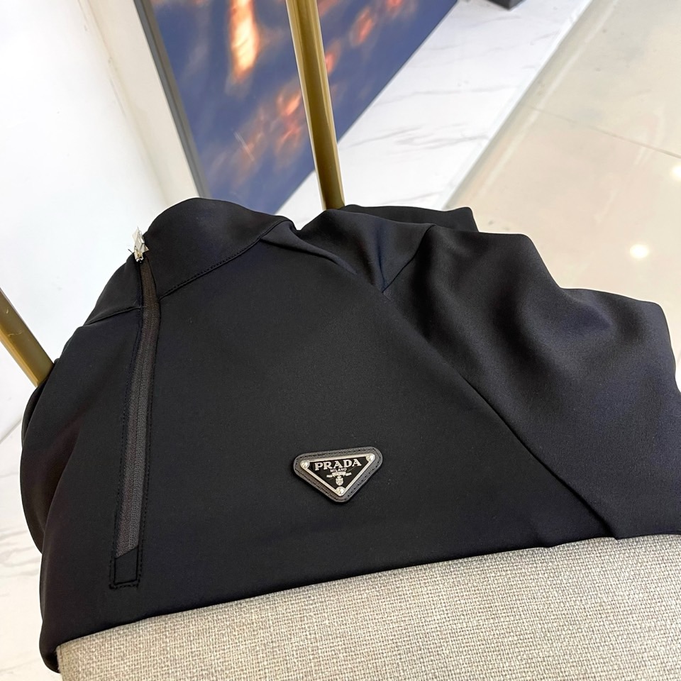 Prad普拉、2025秋冬长袖卫衣T恤。PRADA白色长袖打底衫，以半拉链立领设计诠释现代主义精髓。左胸