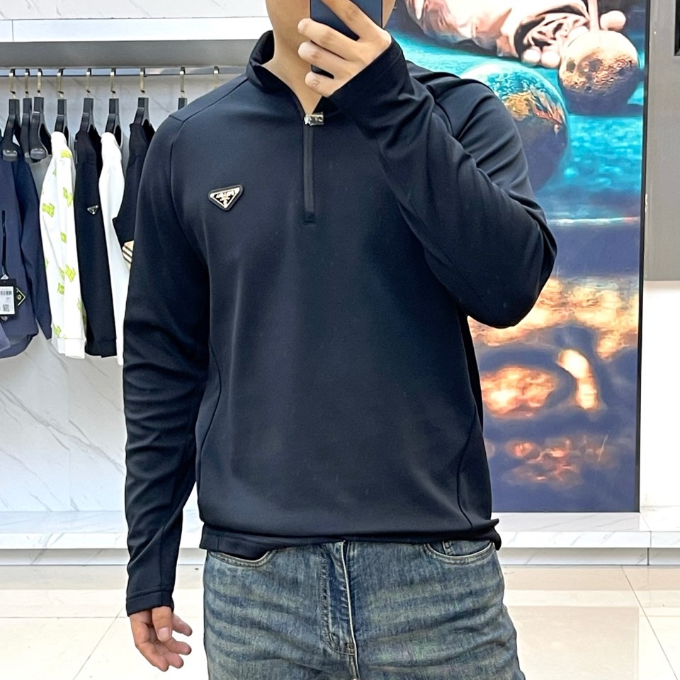 Prad普拉、2025秋冬长袖卫衣T恤。PRADA白色长袖打底衫，以半拉链立领设计诠释现代主义精髓。左胸