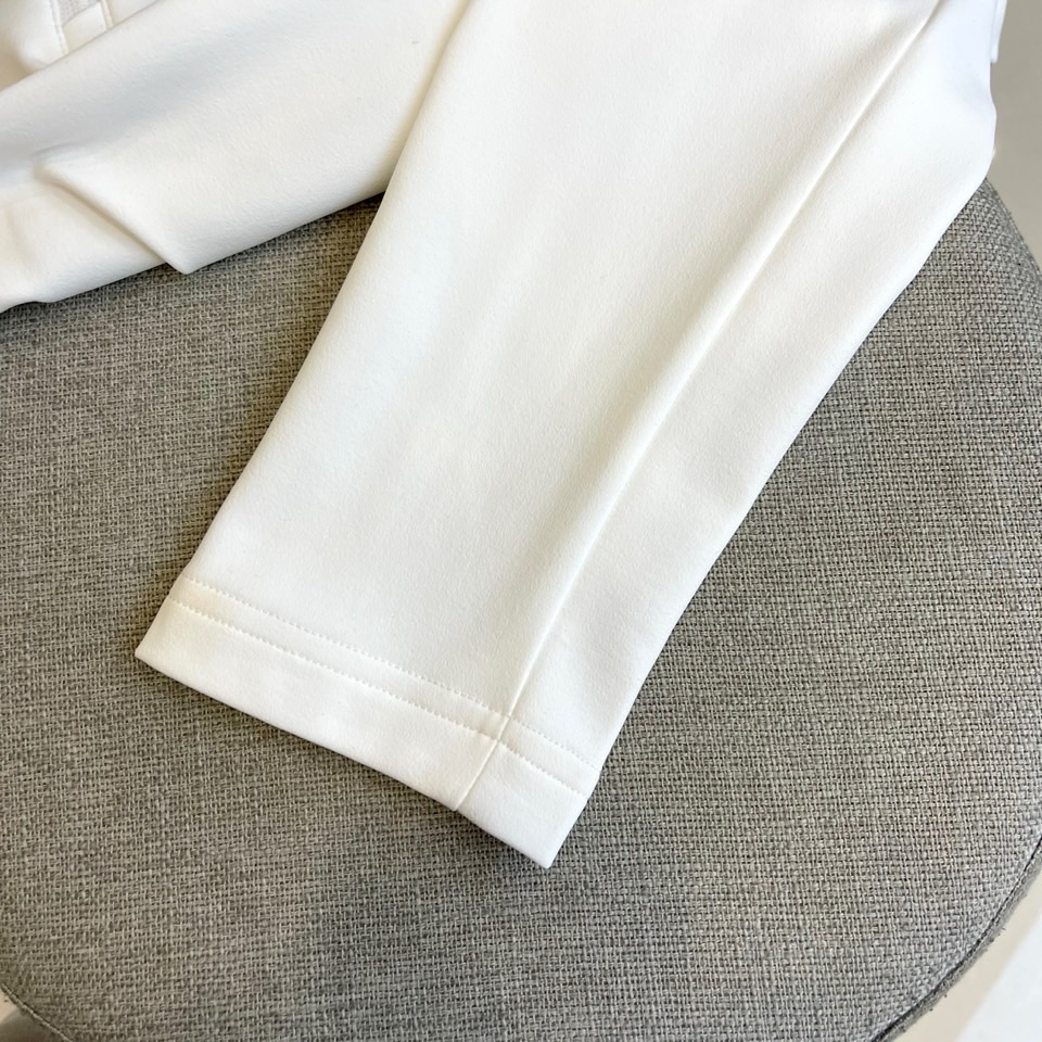 Prad普拉、2025秋冬长袖卫衣T恤。PRADA白色长袖打底衫，以半拉链立领设计诠释现代主义精髓。左胸