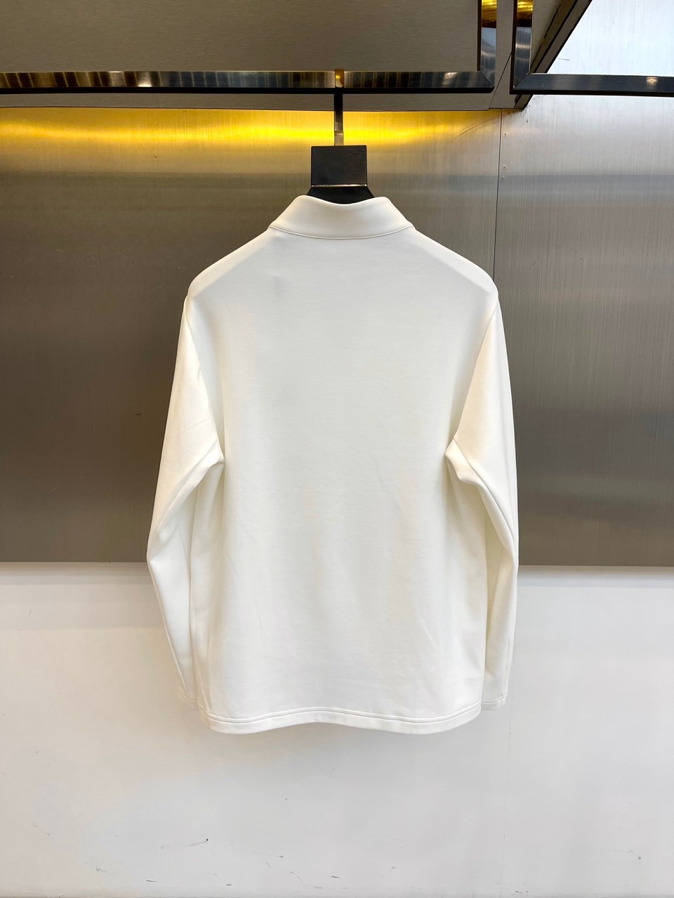 Prad普拉、2025秋冬长袖卫衣T恤。PRADA白色长袖打底衫，以半拉链立领设计诠释现代主义精髓。左胸