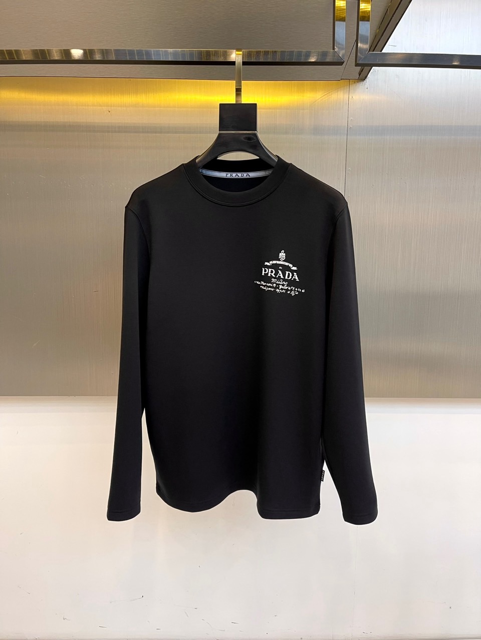 Prad普拉、2025秋冬长袖T恤卫衣。左胸烫金皇冠与手写体