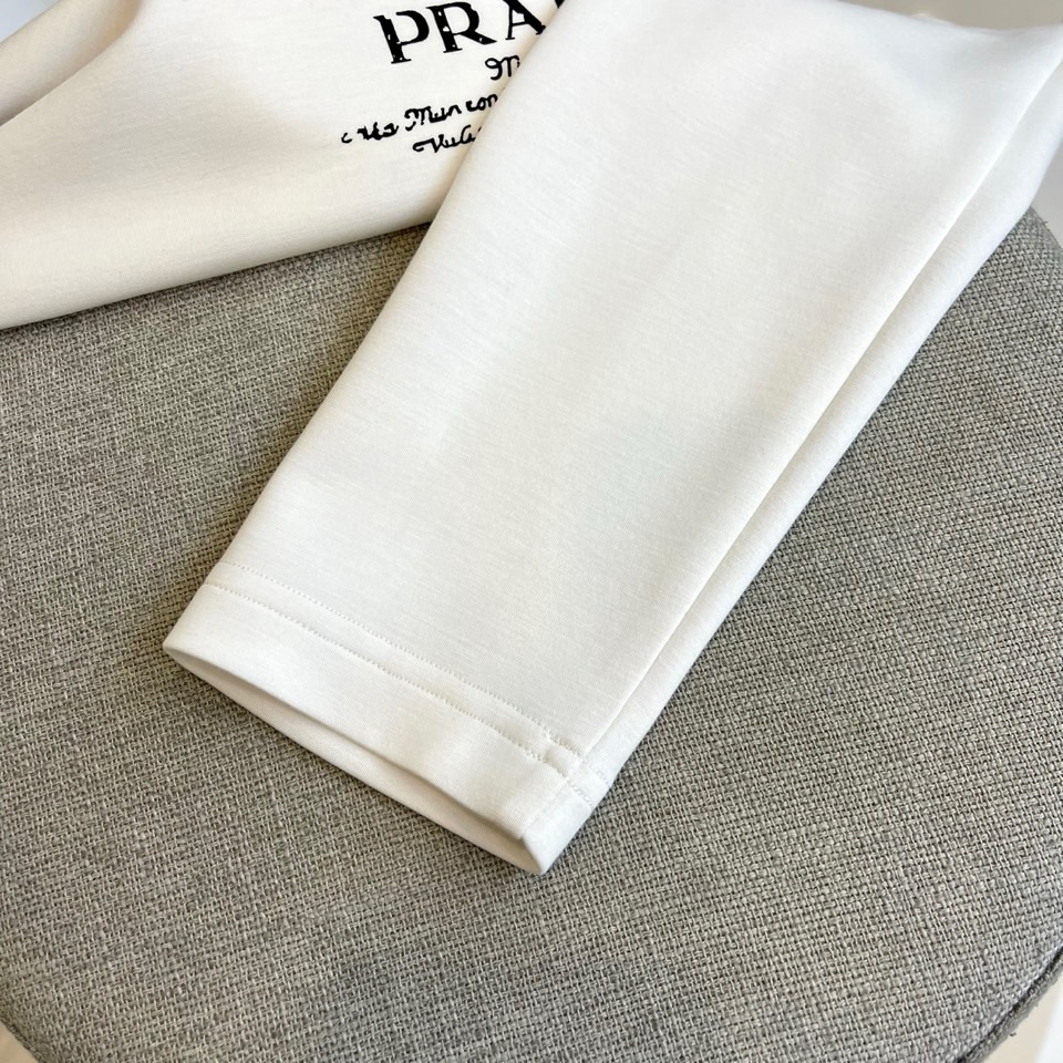 Prad普拉、2025秋冬长袖T恤卫衣。左胸烫金皇冠与手写体