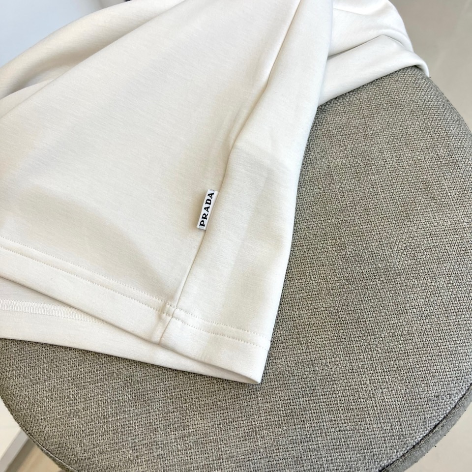 Prad普拉、2025秋冬长袖T恤卫衣。左胸烫金皇冠与手写体
