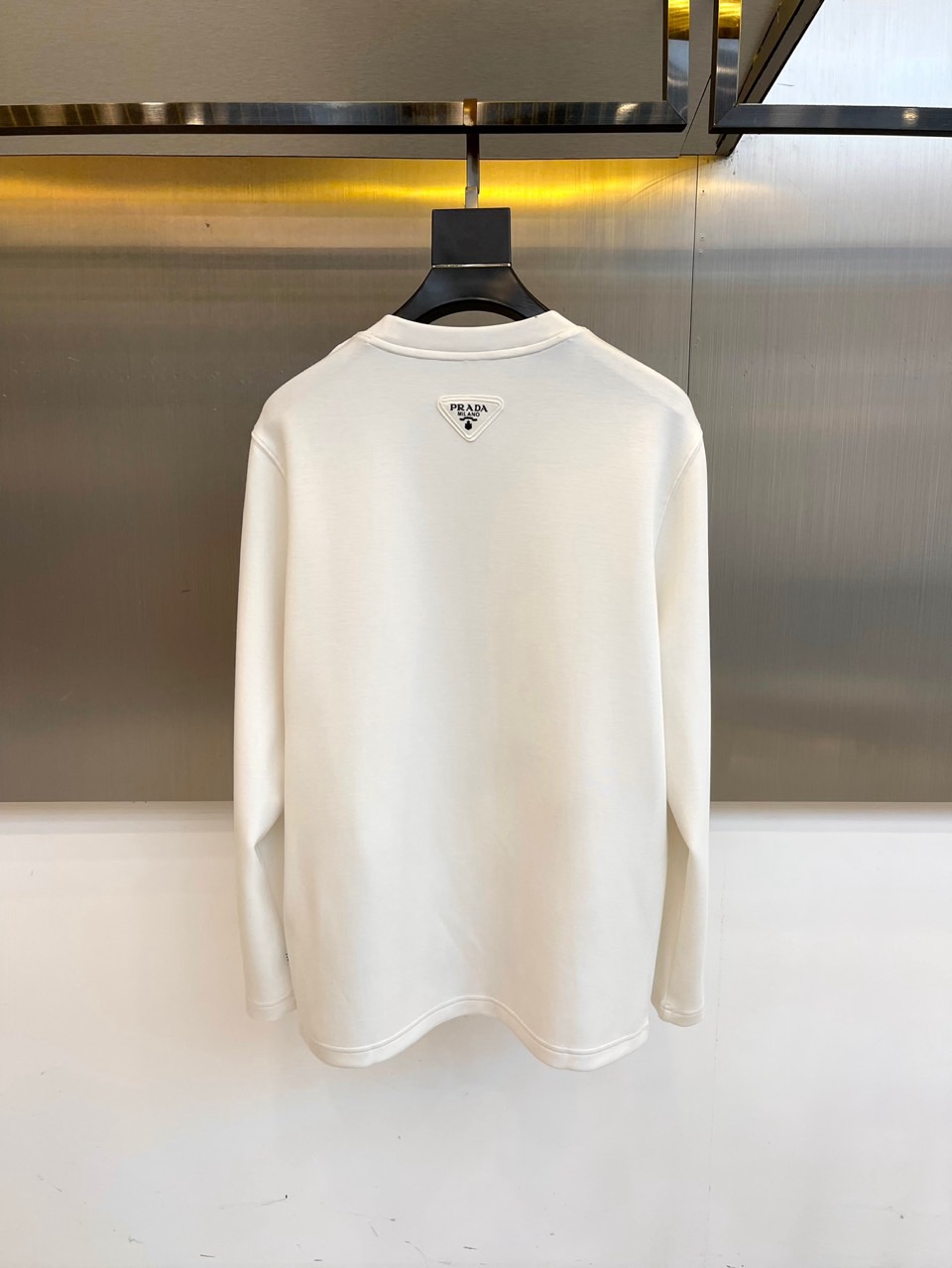 Prad普拉、2025秋冬长袖T恤卫衣。左胸烫金皇冠与手写体