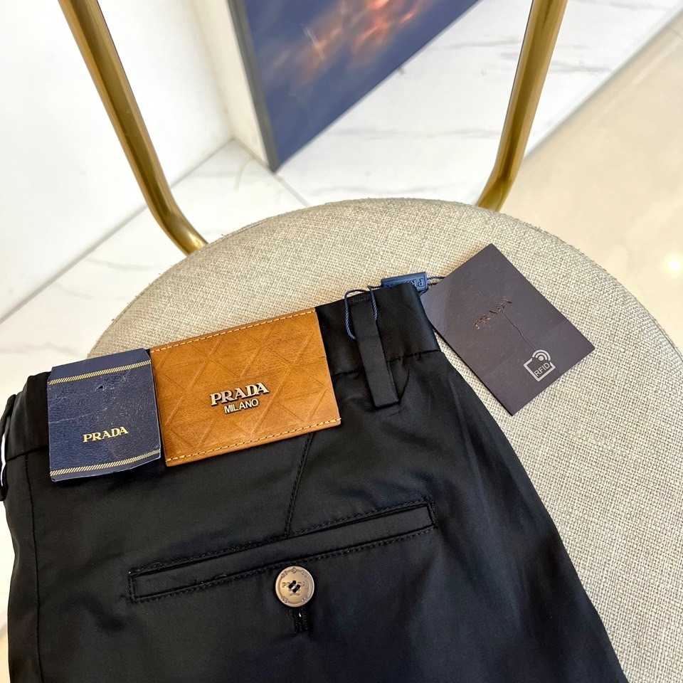 Prad普拉、2025秋冬新品商务休闲长裤。一抹红色，足以定义身份。这条PRADA黑色休闲长裤以极简轮廓