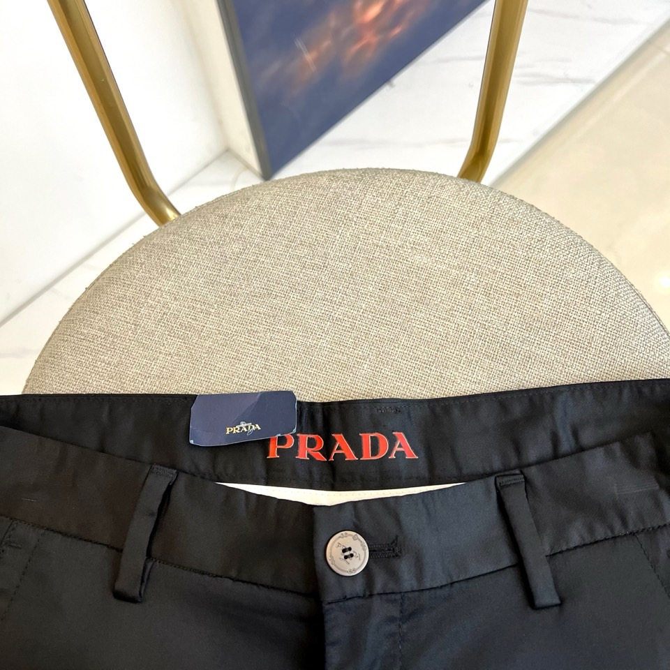 Prad普拉、2025秋冬新品商务休闲长裤。一抹红色，足以定义身份。这条PRADA黑色休闲长裤以极简轮廓